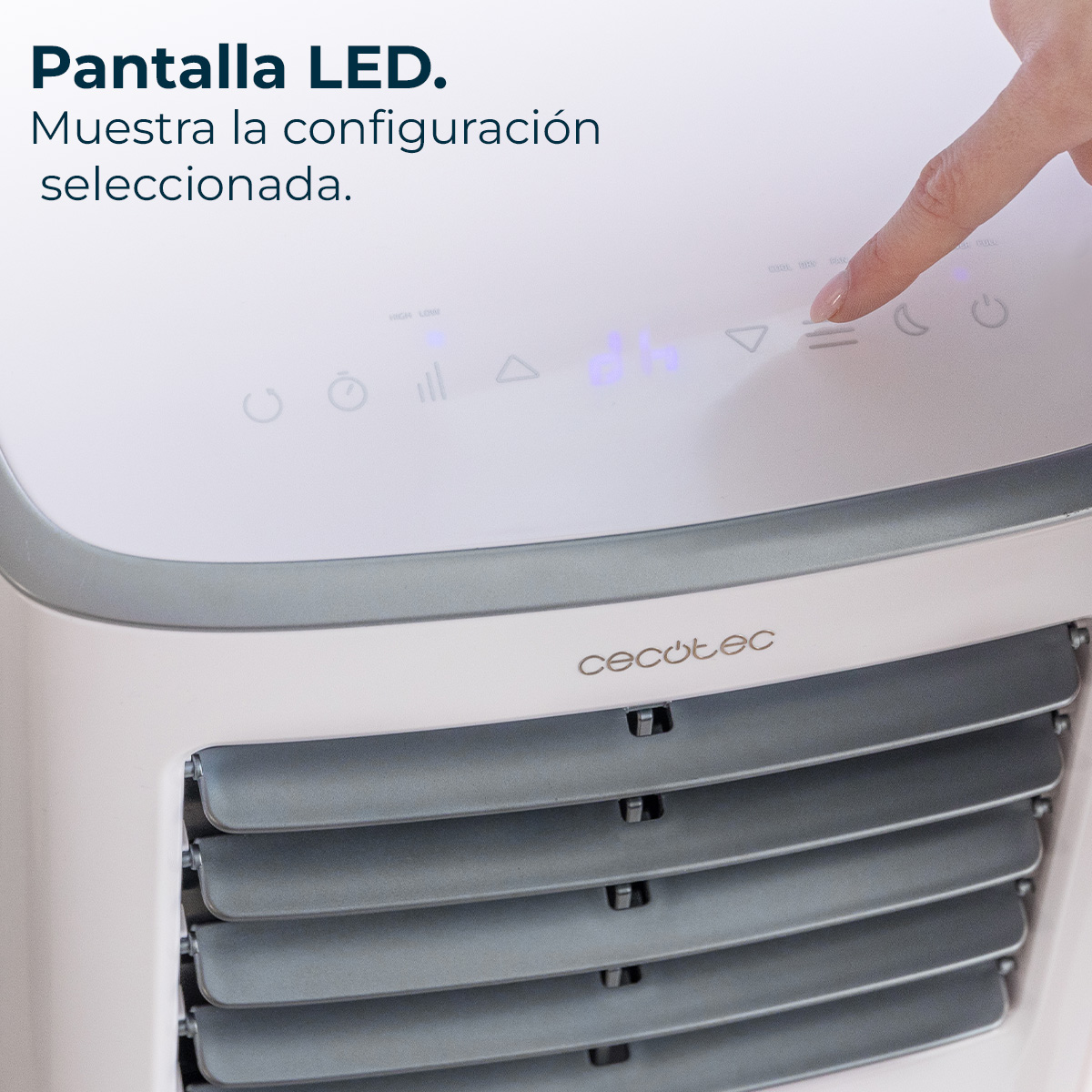 Primer plano del aire acondicionado. Una mano presiona un botón en la pantalla LED. La escritura dice: Cecotec.