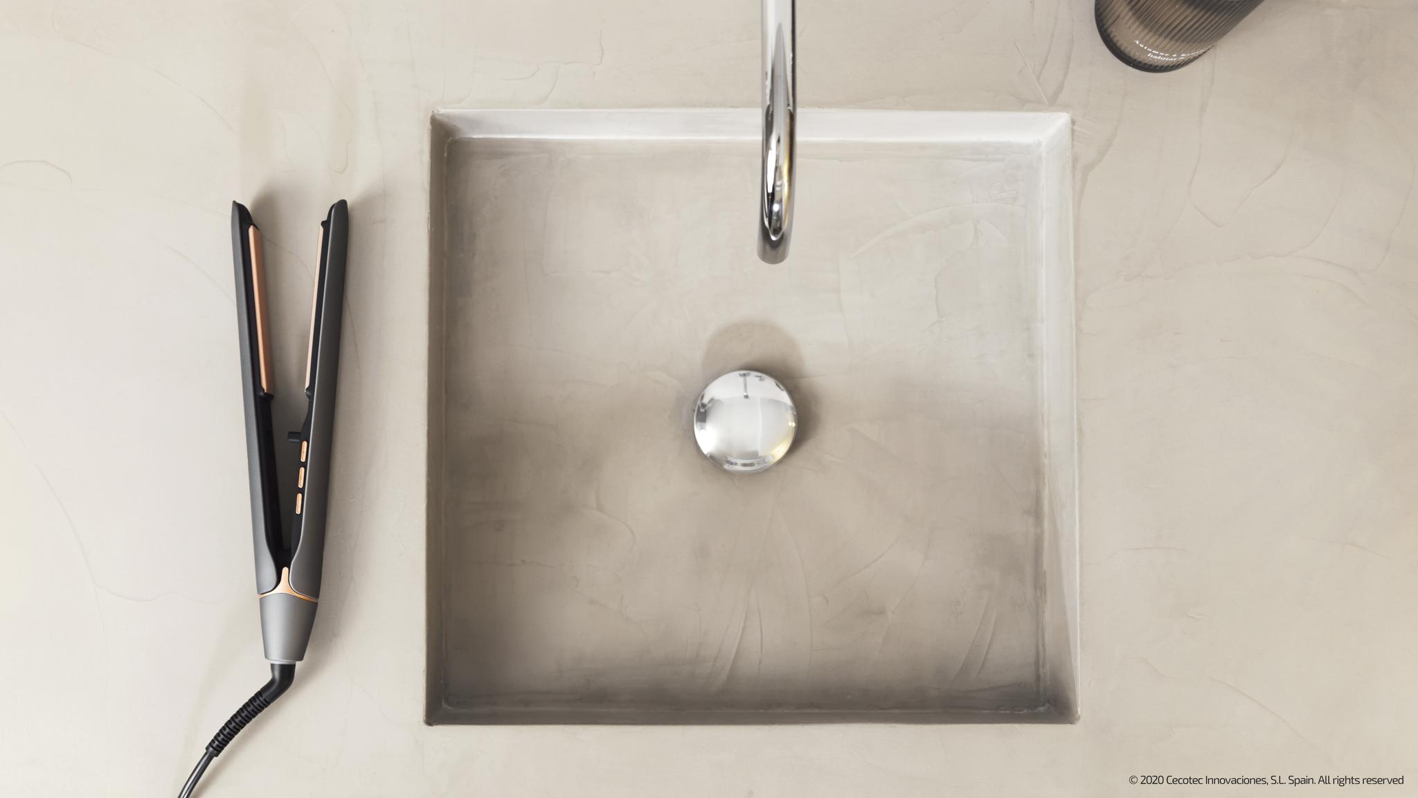 Umywalka z kranem i prostownicą obok.