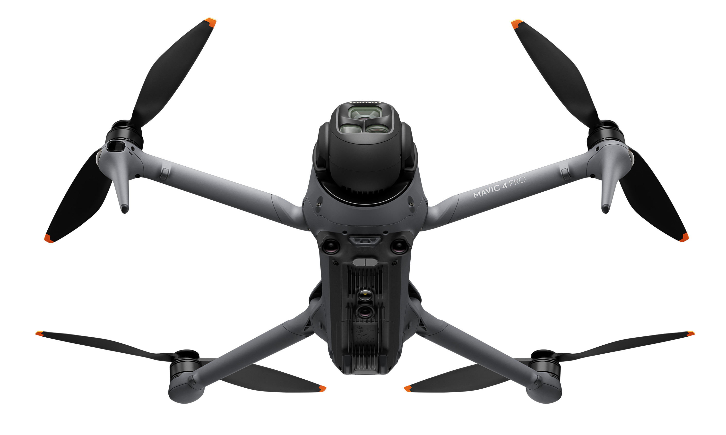 Szary dron z czterema czarnymi śmigłami. Białe tło. Dron ma kamerę z przodu.