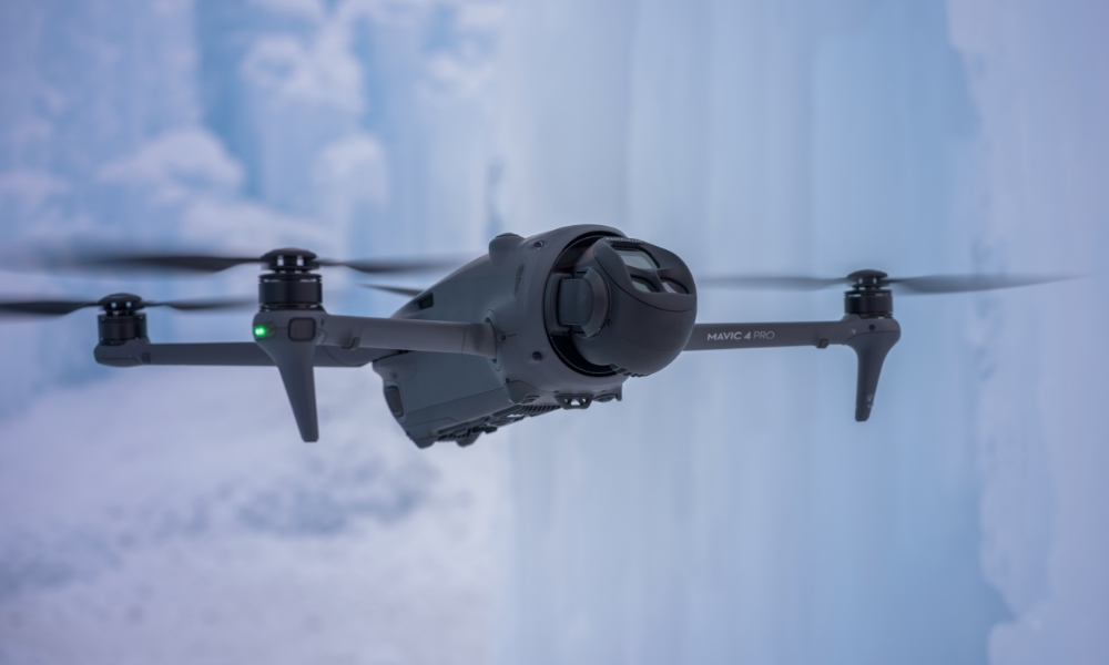 Dron lecący na niebie, z rozmytym tłem chmur.