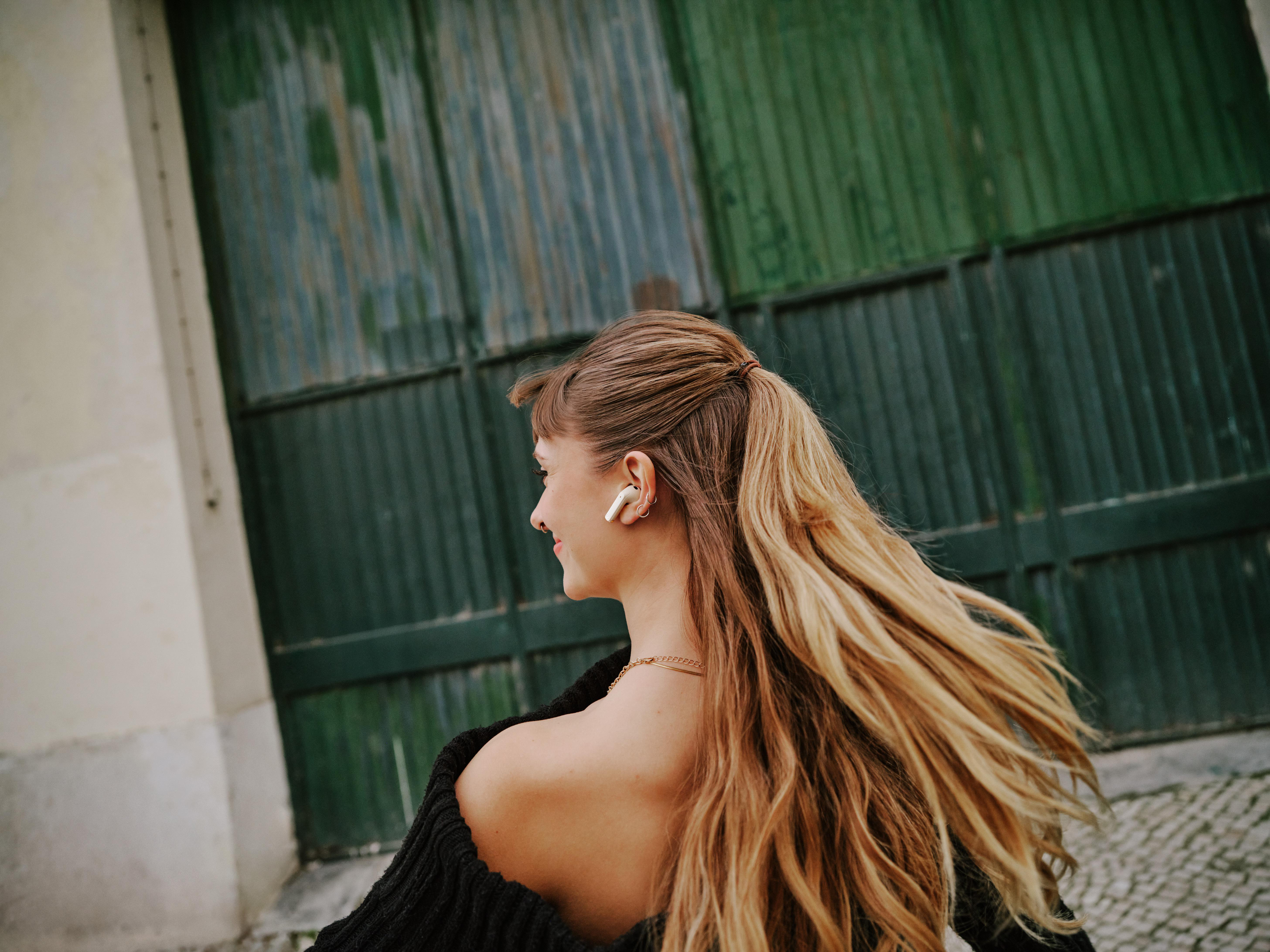 Frau mit Kopfhörern, die sich wegdreht.