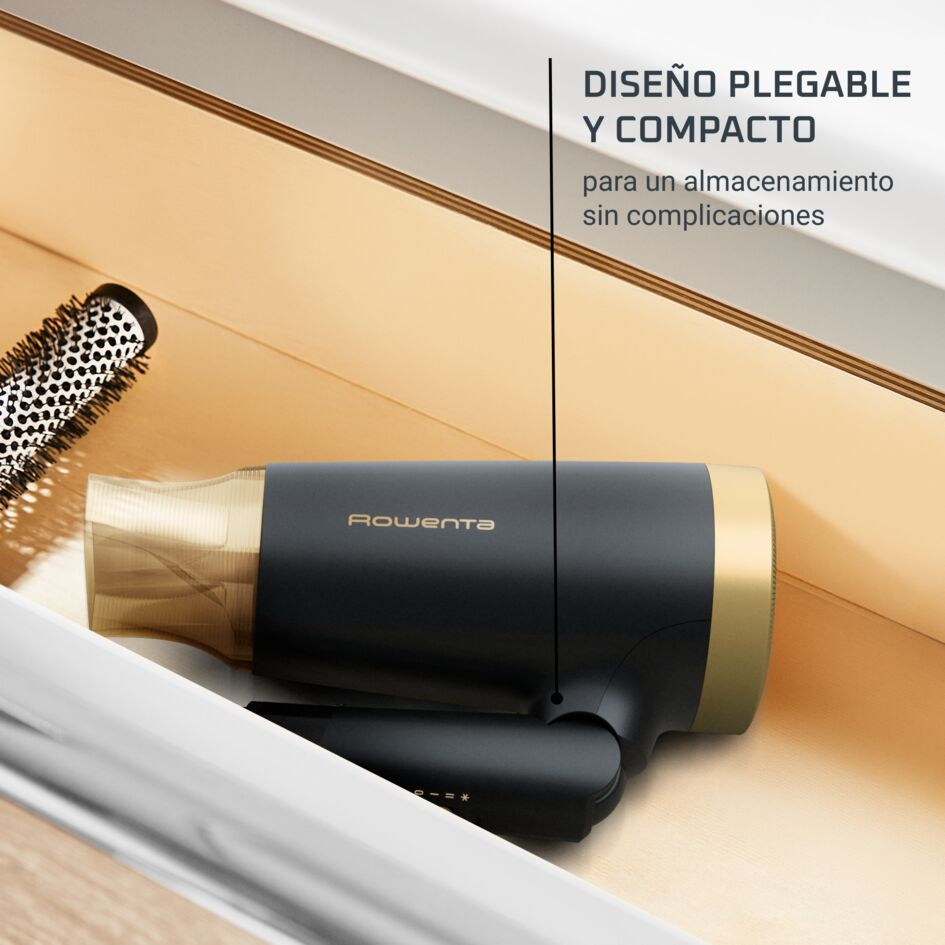 Secador de pelo Rowenta negro y dorado en un cajón con un cepillo. Texto: "Diseño plegable y compacto para un almacenamiento fácil."