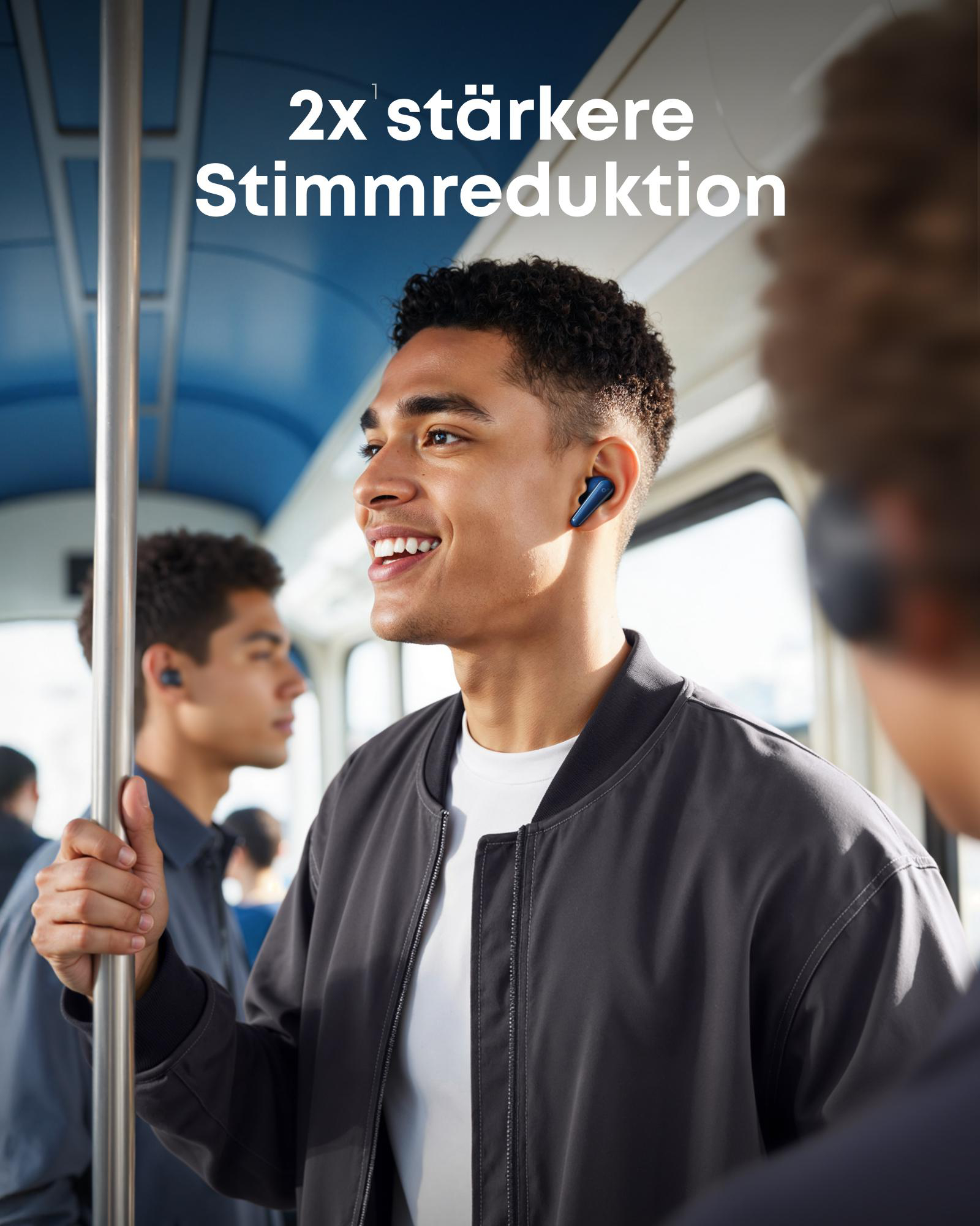 Ein Mann im Zug mit blauen Ohrhörern, lächelnd, Text '2x stärkere Stimmreduktion'.