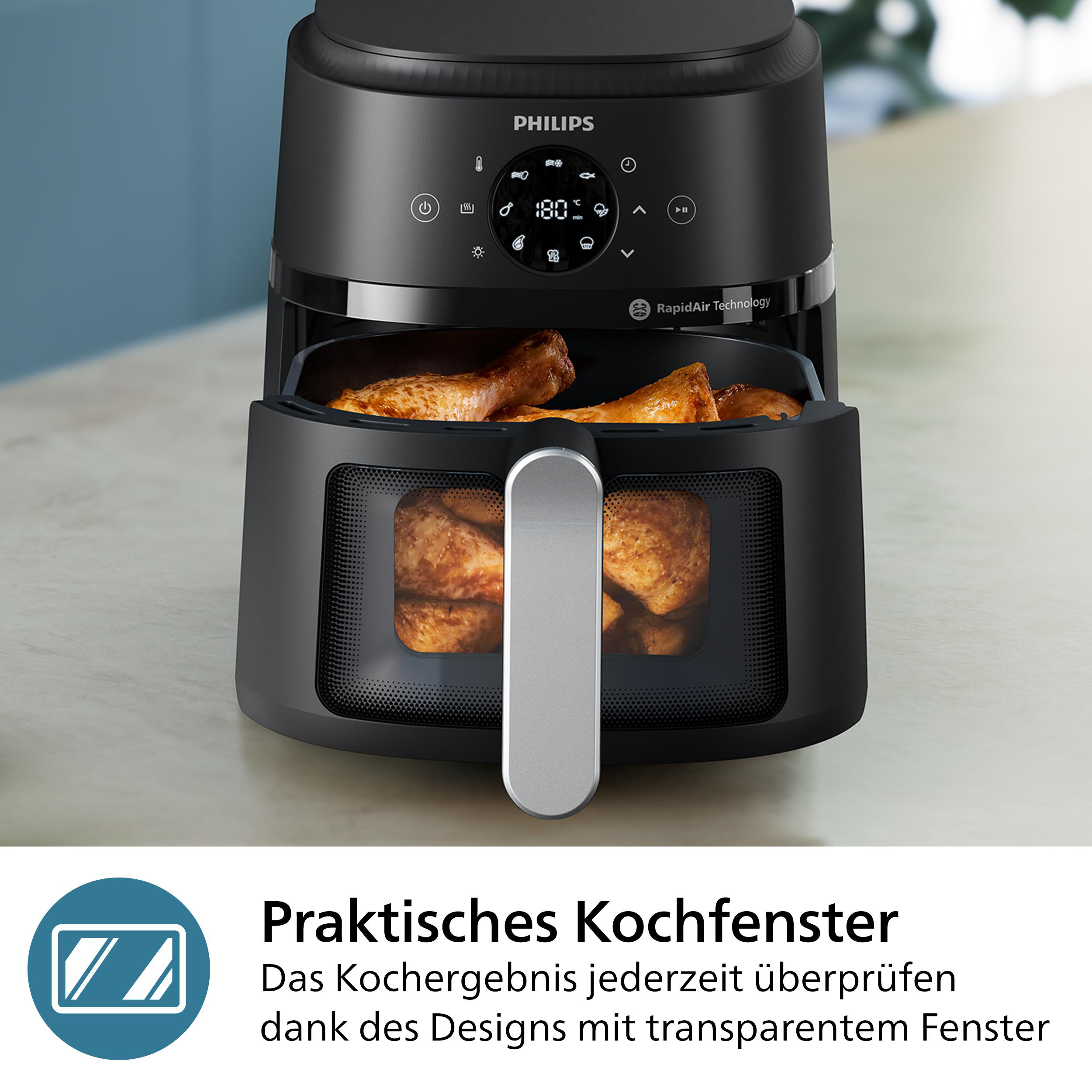 Schwarze Airfryer mit Hähnchenschenkeln im Inneren, die von einer Person auf einem weißen Hintergrund verwendet wird.