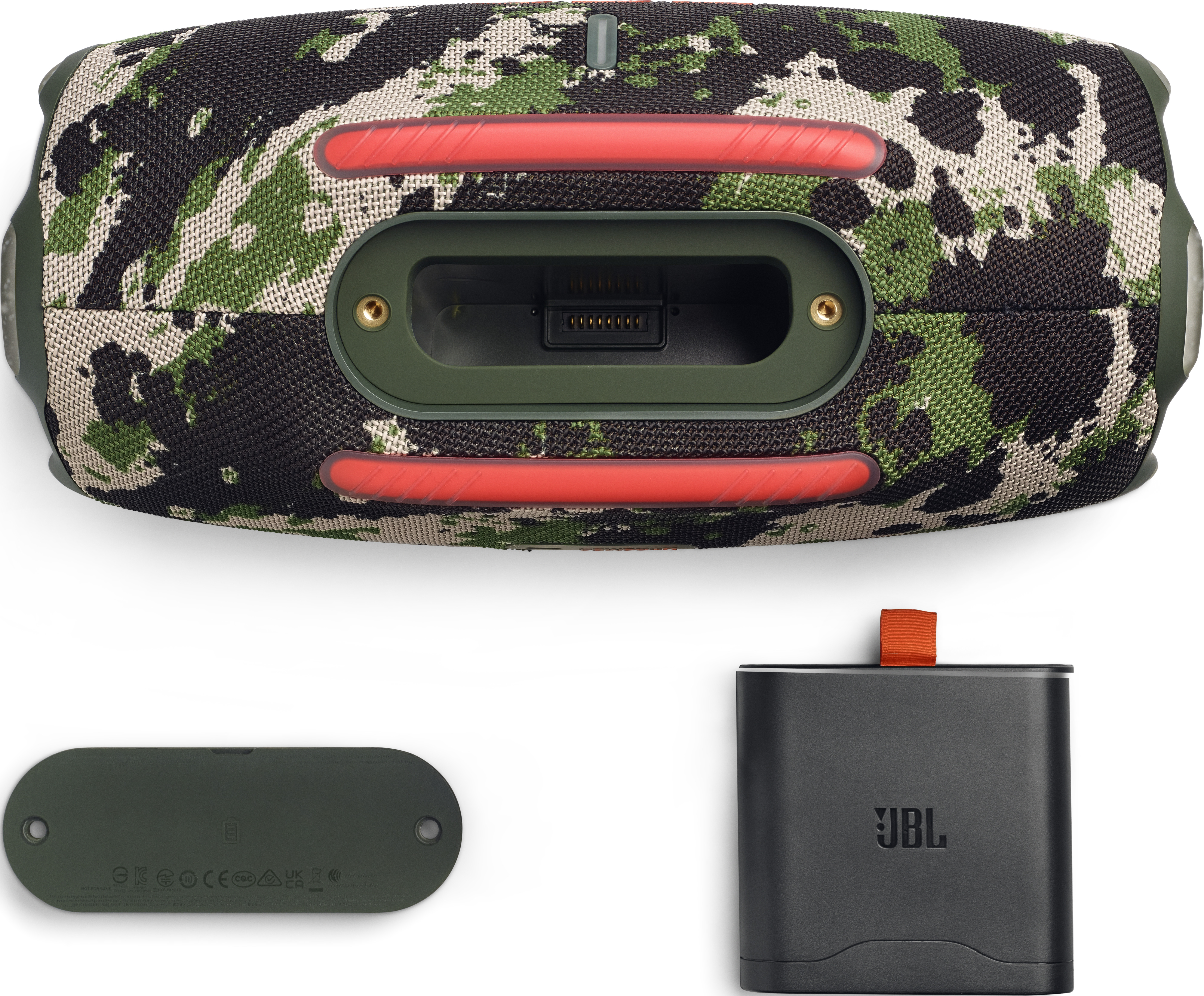 Une enceinte JBL avec motif camouflage, port de charge et accessoires, dont un chargeur noir.
