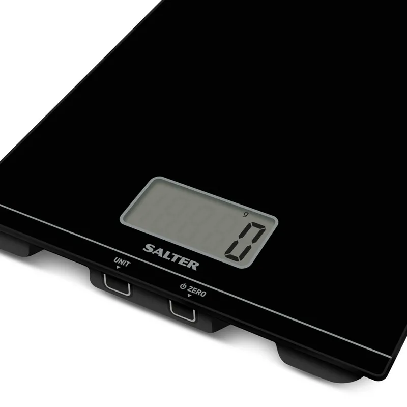 Közelkép egy fekete konyhai mérlegről digitális kijelzővel, 0 g-ot mutat. Salter márka, vezérlőgombokkal.
