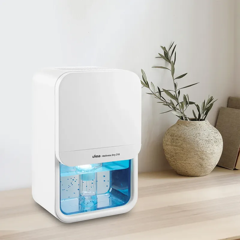 Fehér Ufesa Wellness Dry 210 készülék asztalon, vázával és növénnyel.