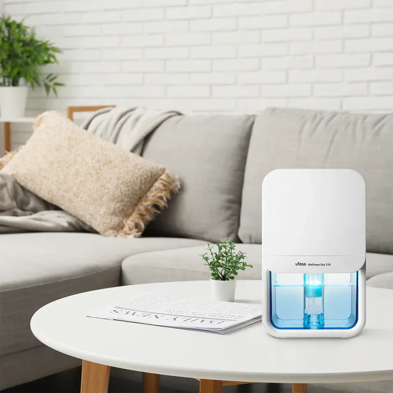 Fehér Ufesa Wellness Dry 210 készülék asztalon, kanapéval és párnákkal.