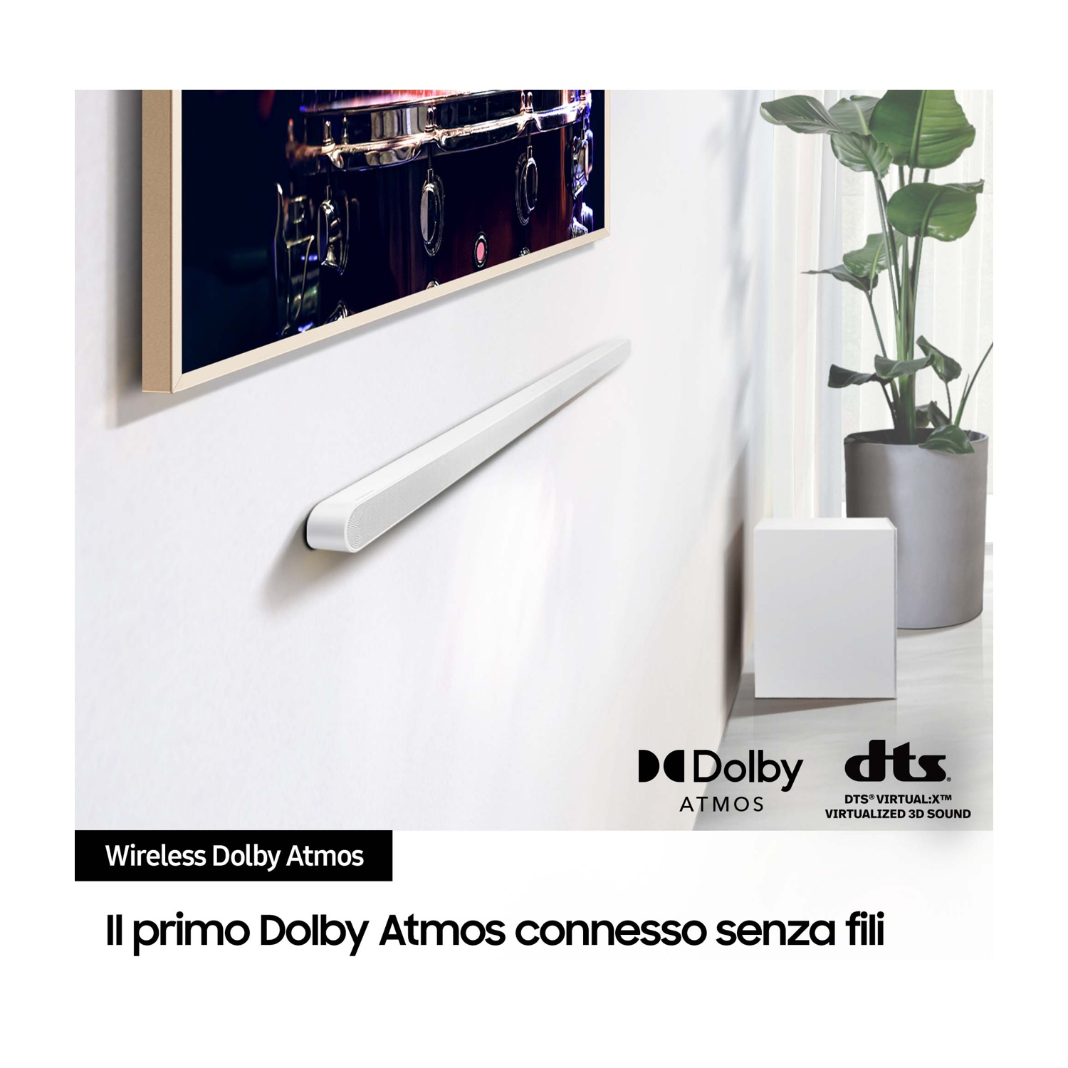 Soundbar bianca a parete, testo "Wireless Dolby Atmos". Un subwoofer è accanto al televisore.