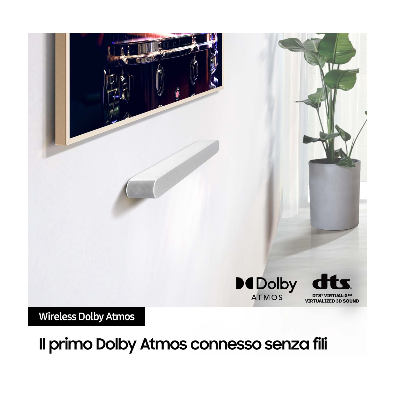 Soundbar bianca a parete, testo "Wireless Dolby Atmos". Un subwoofer è accanto al televisore.