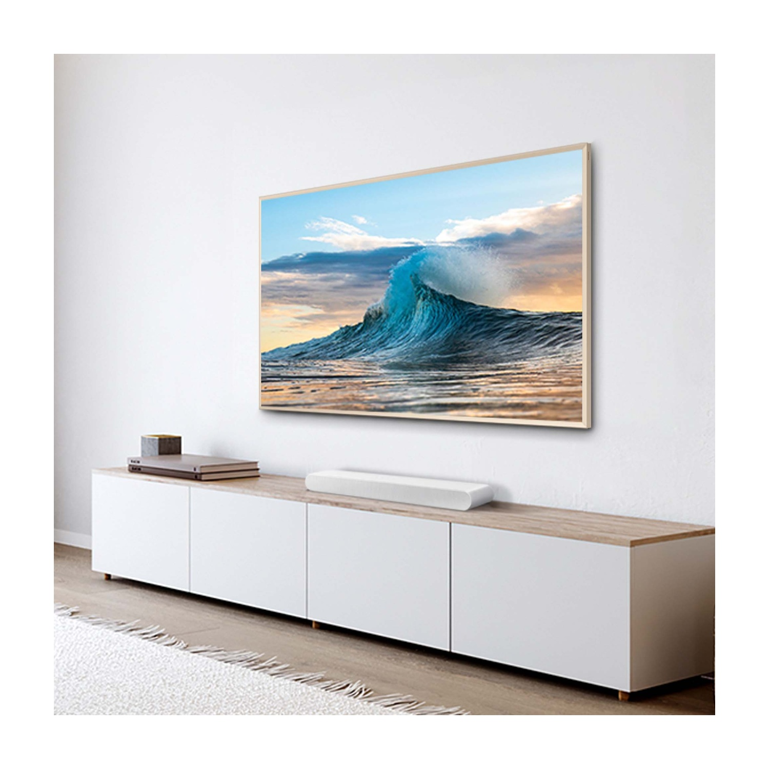 Una soundbar bianca su un mobile sotto una TV con un'immagine di onde.