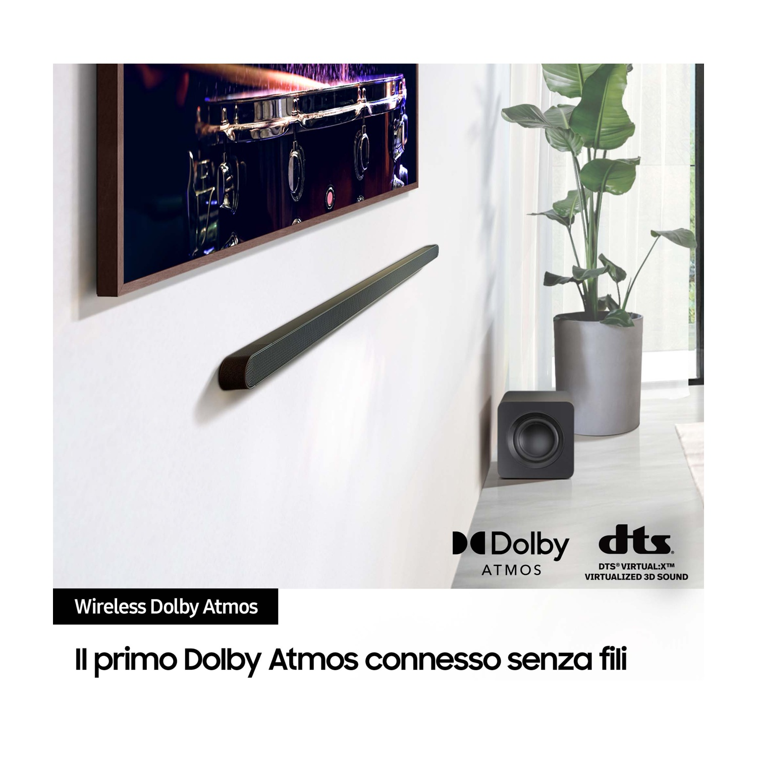 Soundbar nera a parete, testo "Wireless Dolby Atmos". Un subwoofer è accanto al televisore.