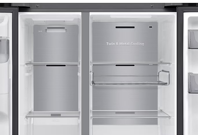 Otwarta komora lodówki z metalowymi półkami. Zawiera tekst 'Twin & Metal Cooling'. Dominują kolory srebrny i biały.