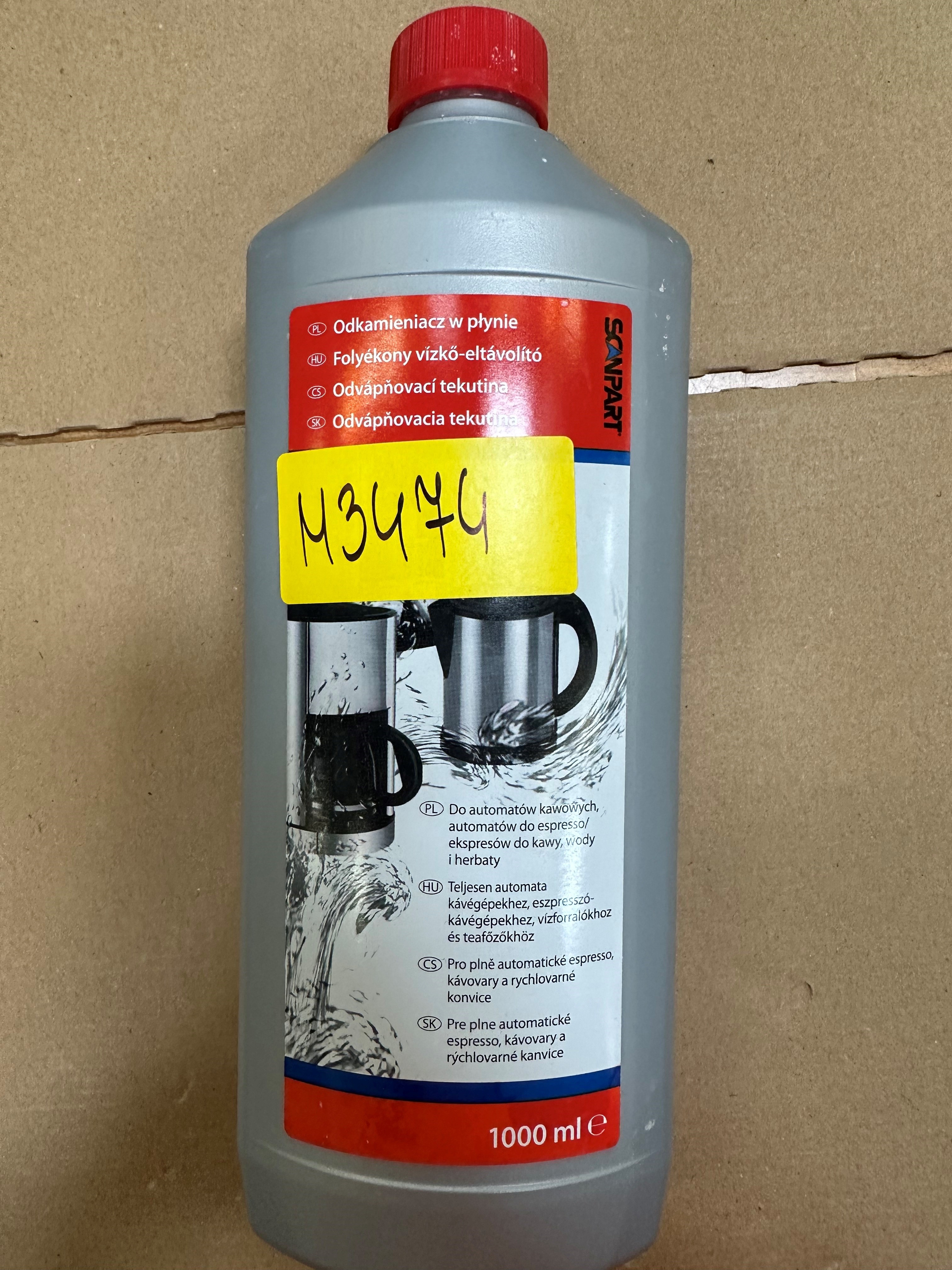 Szara butelka z czerwoną zakrętką. Etykieta zawiera tekst i obrazy. Tło jest brązowe.