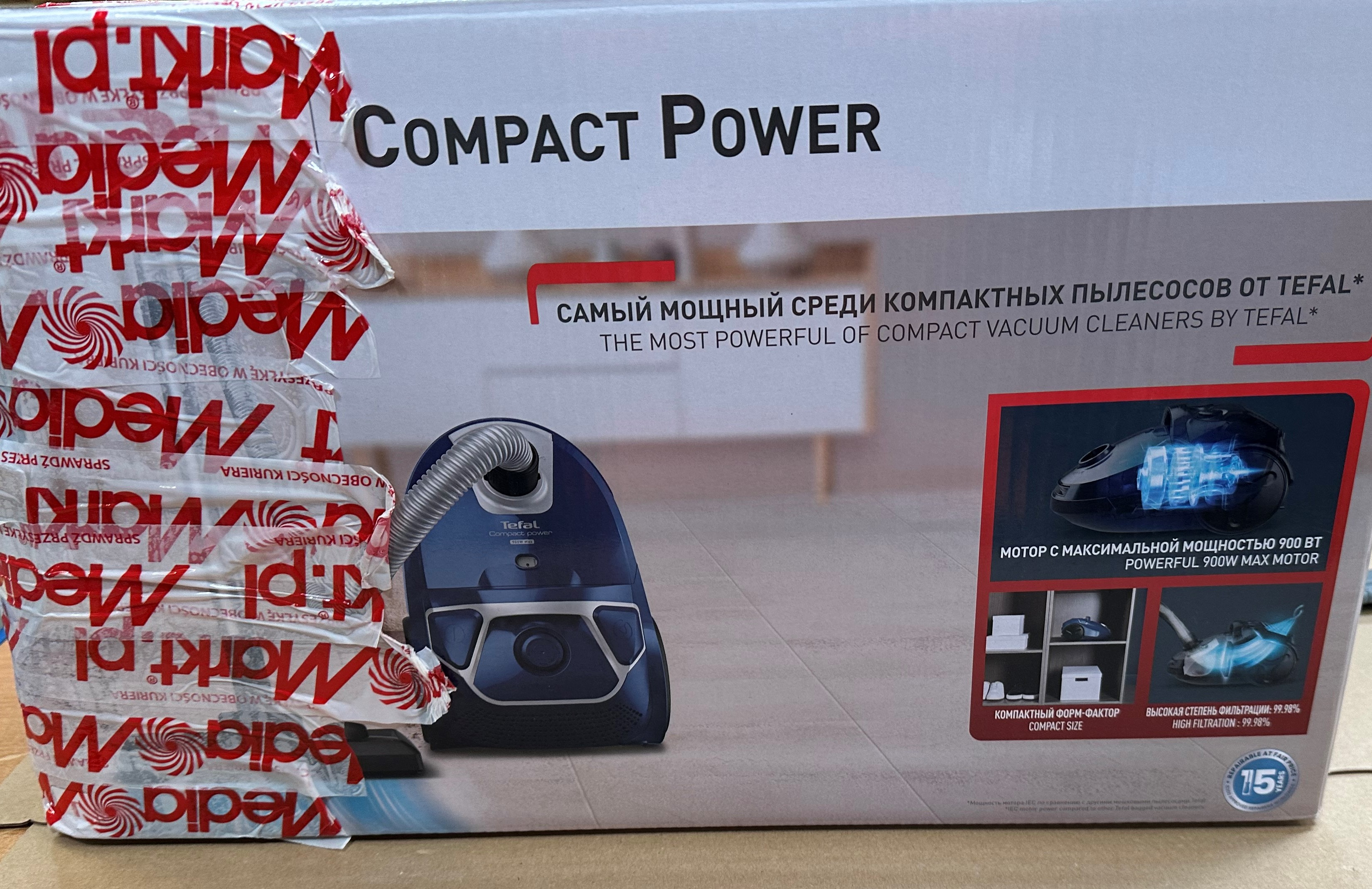 Kartonowe pudełko od odkurzacza Tefal Compact Power, z tekstem i obrazami.