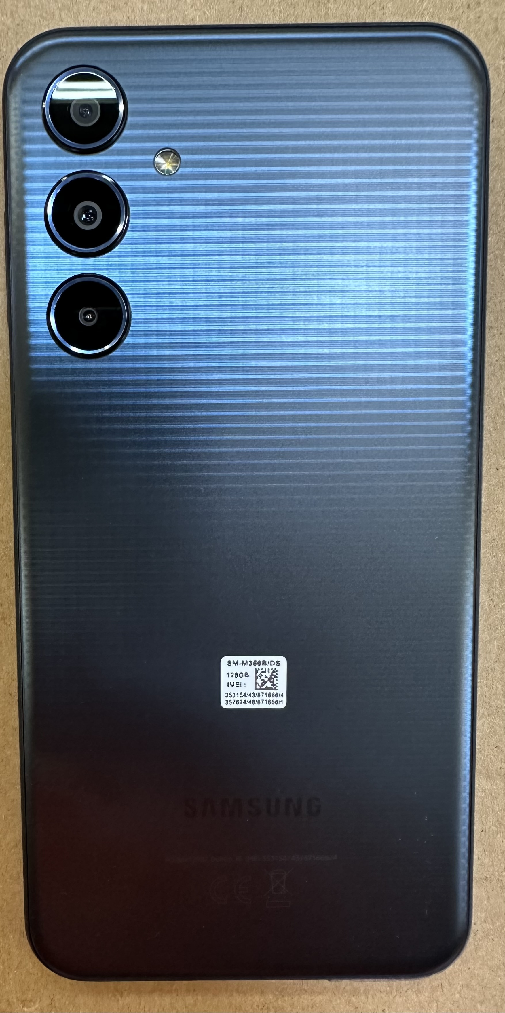 Tył czarnego smartfona z trzema aparatami i logo Samsung.