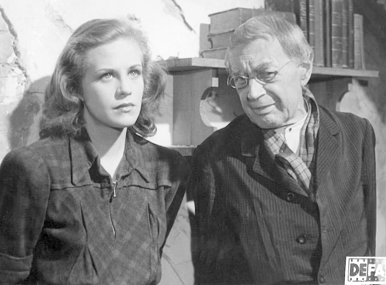 Schwarz-weiß-Foto von zwei Personen in einem Raum. Eine Frau und ein Mann stehen nebeneinander.