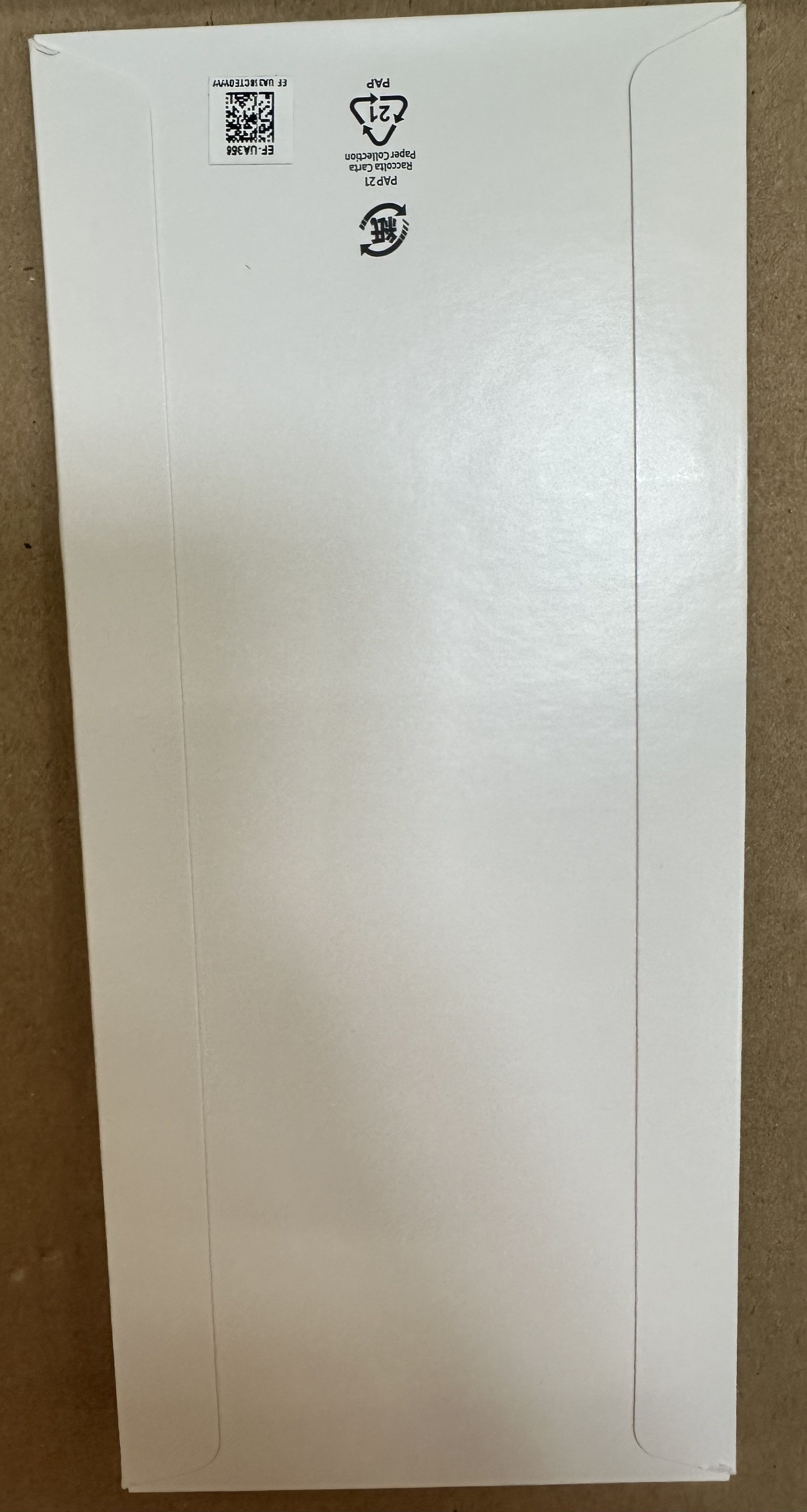 Białe, podłużne opakowanie. Kod QR i symbole recyklingu. Puste opakowanie.