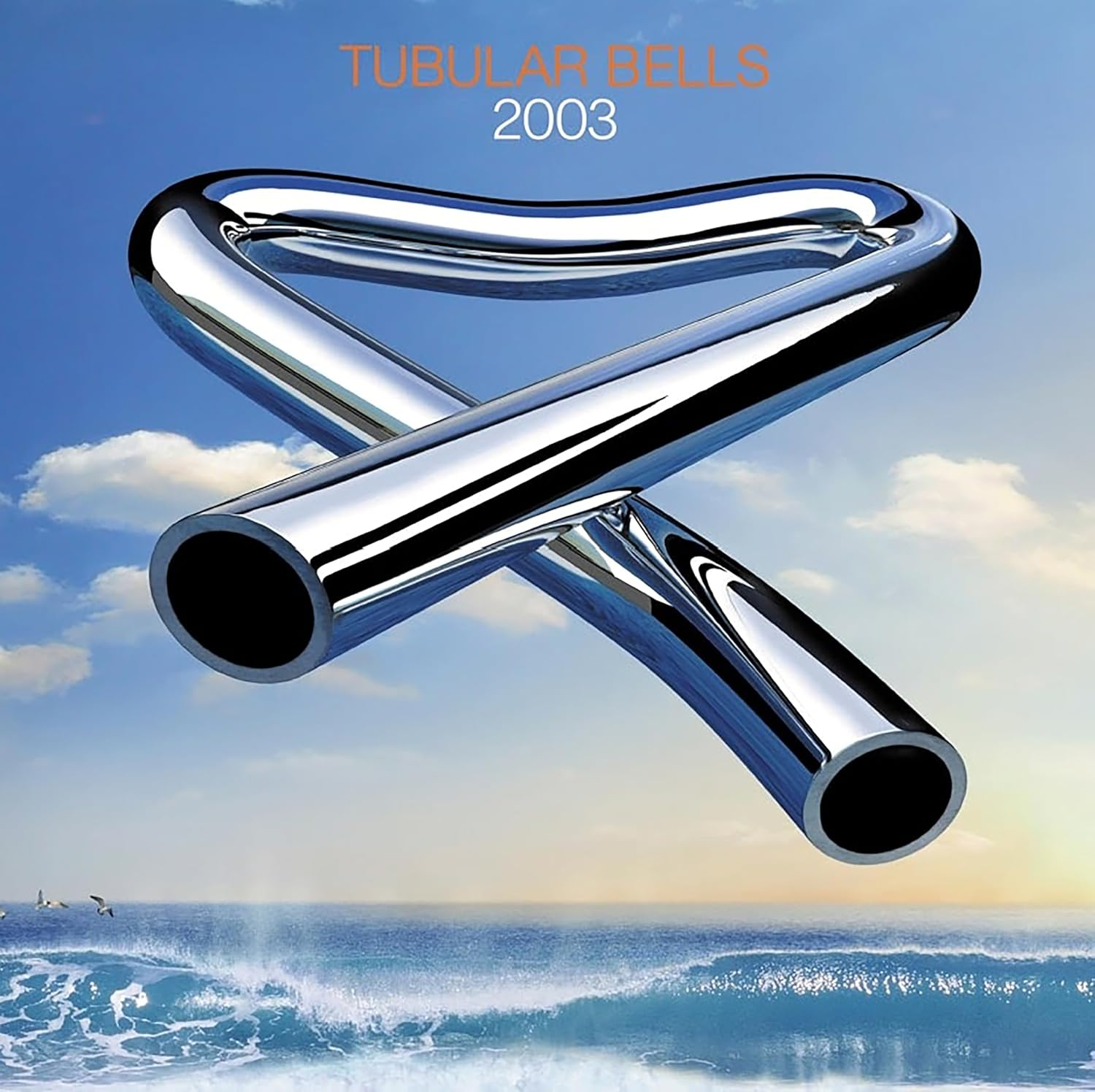 Két fémcső egy ívet alkot a kék ég és a tenger előtt. A "Tubular Bells 2003" cím látható.