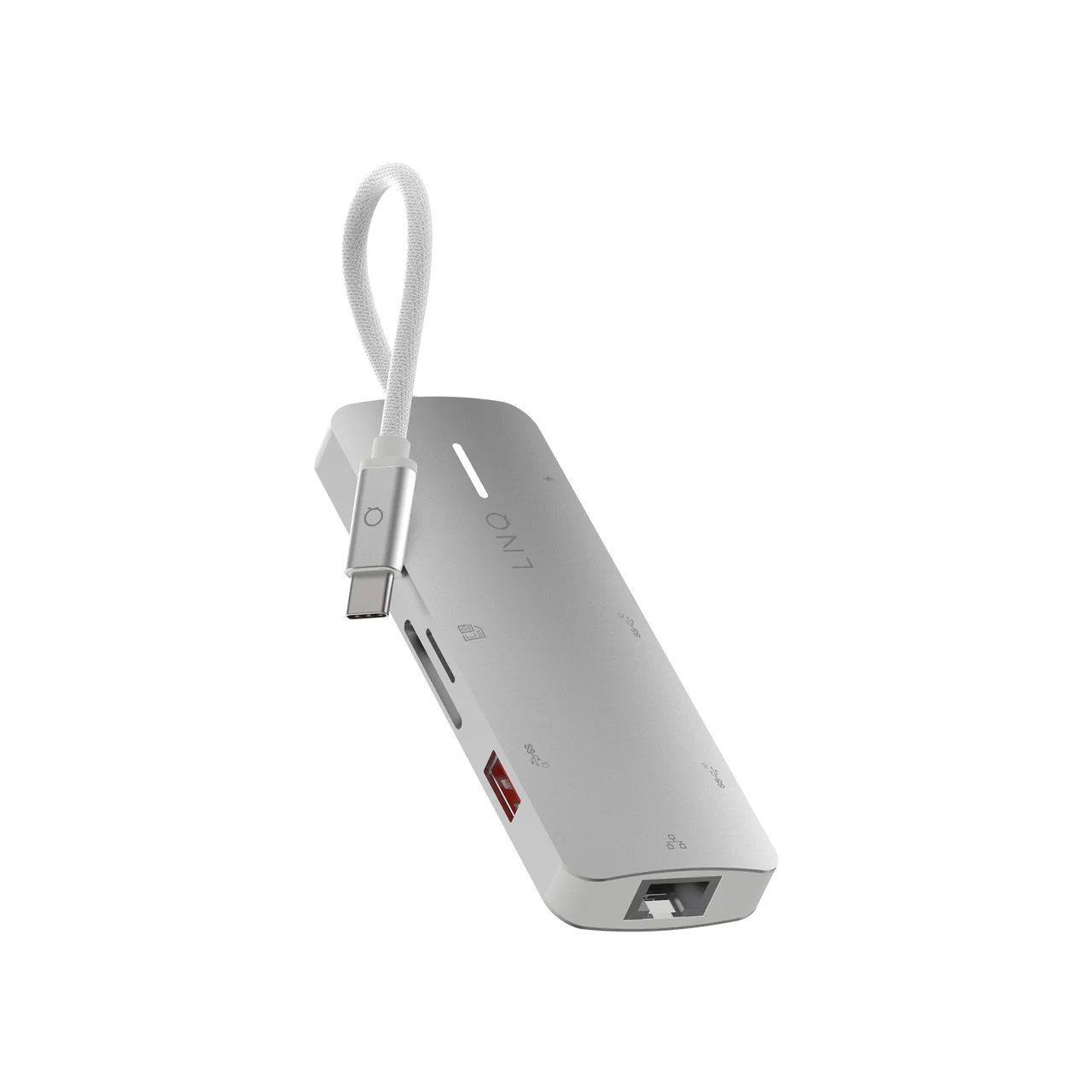 Un concentrador USB-C plateado, vista en ángulo, con múltiples puertos sobre fondo negro.