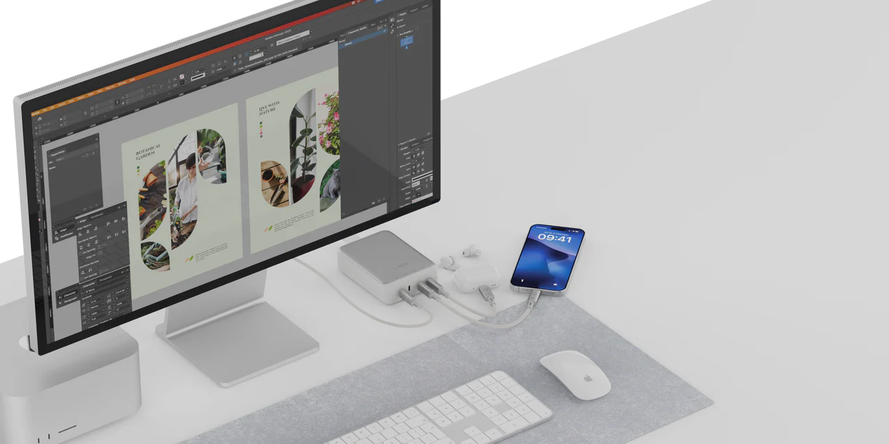Una configuración de computadora con un concentrador que conecta un monitor, teléfono y accesorios.