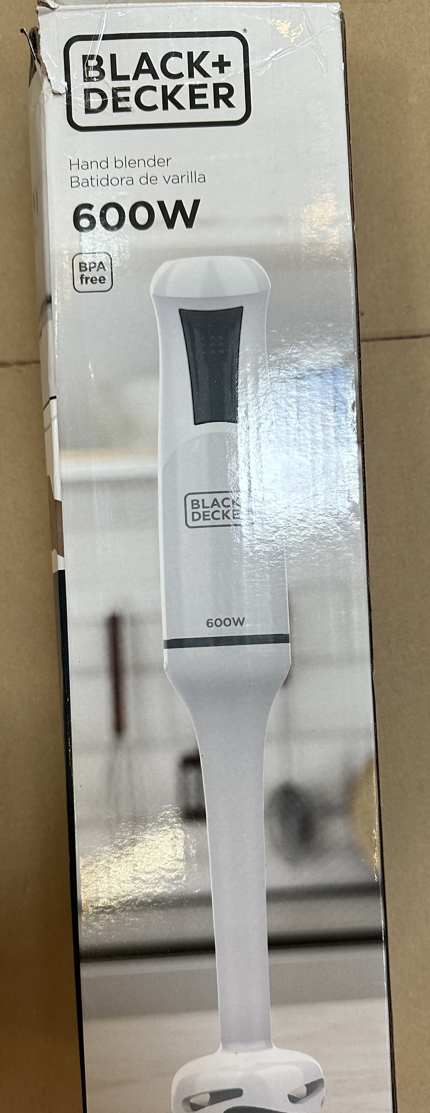 Zbliżenie na pudełko blendera ręcznego Black+Decker. Pudełko jest białe ze zdjęciem blendera i oznaczeniem 600W.