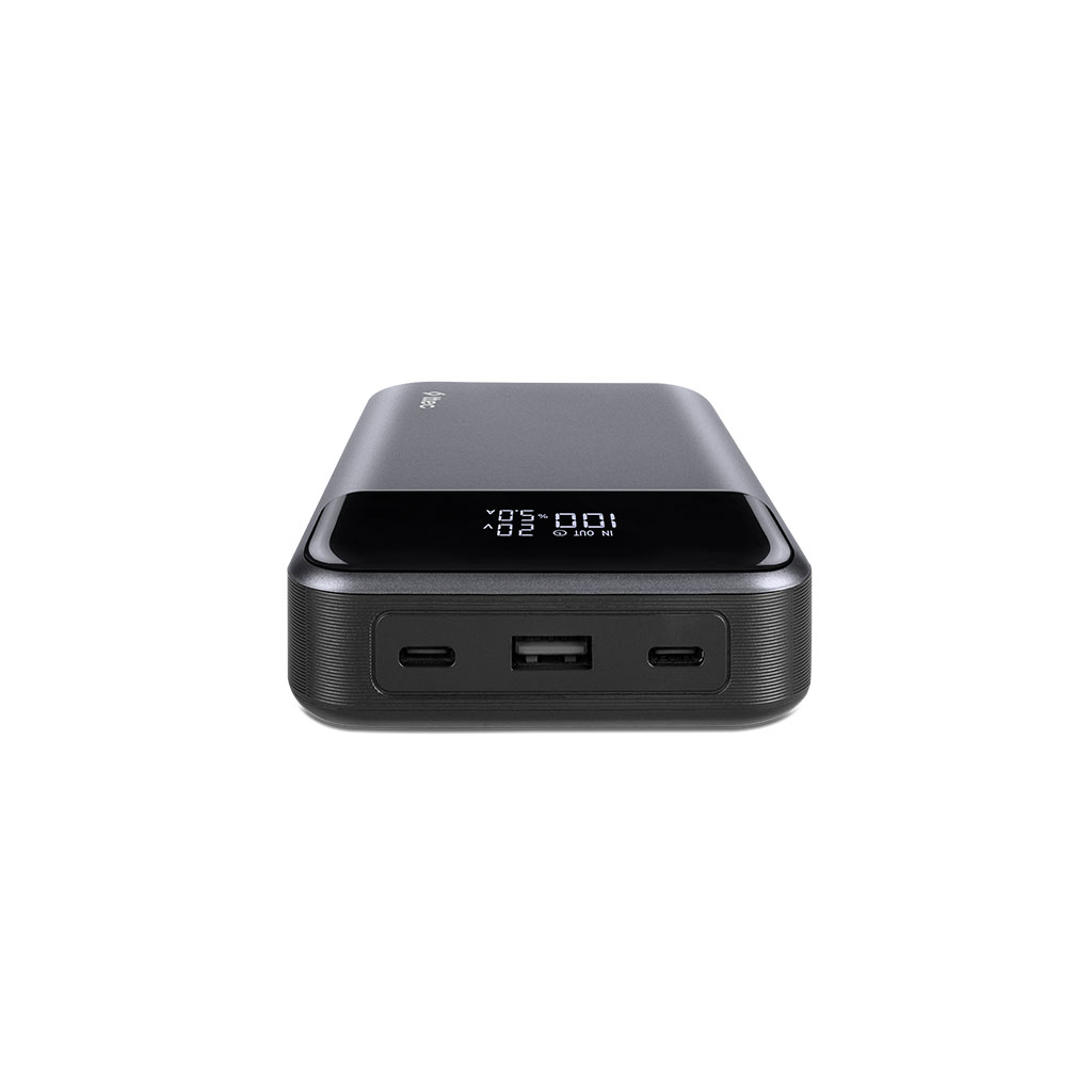 USB portları ve voltajı ve pil yüzdesini gösteren ekranı olan koyu gri güç bankası. Beyaz zemin.