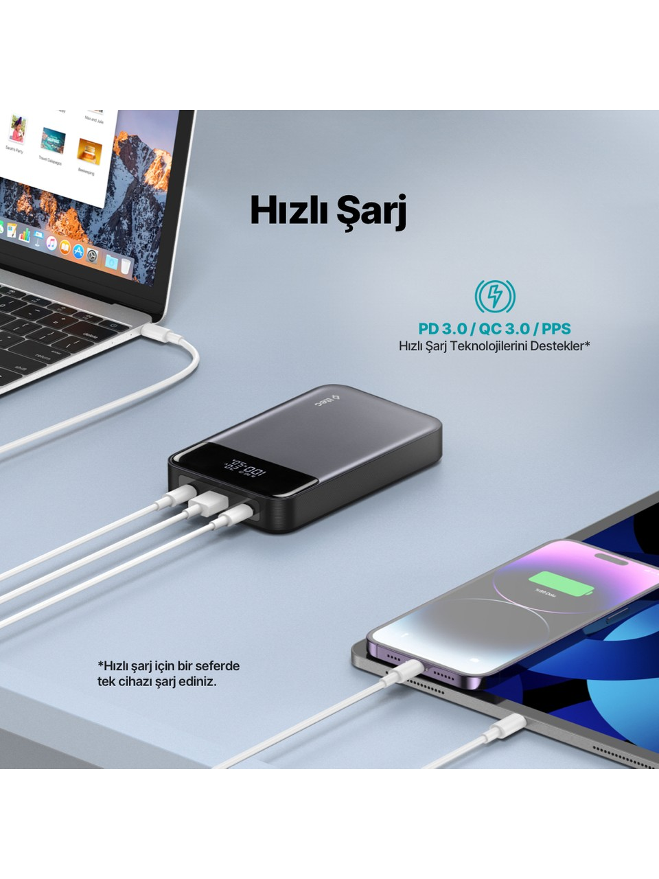 Power bank beyaz kablolarla dizüstü bilgisayar, telefon ve tableti şarj ediyor.