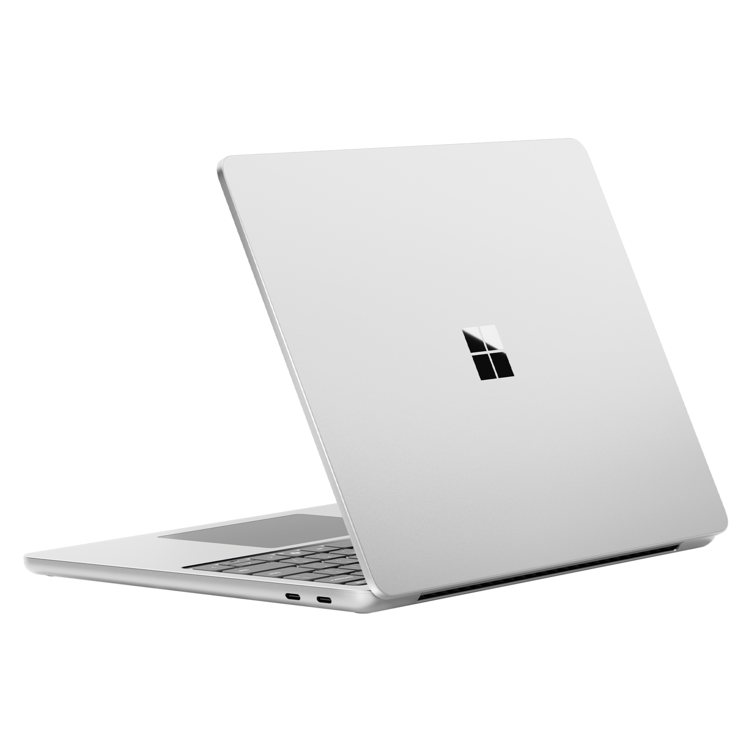A silver laptop, slightly open, with the Microsoft logo on the back. Black background.