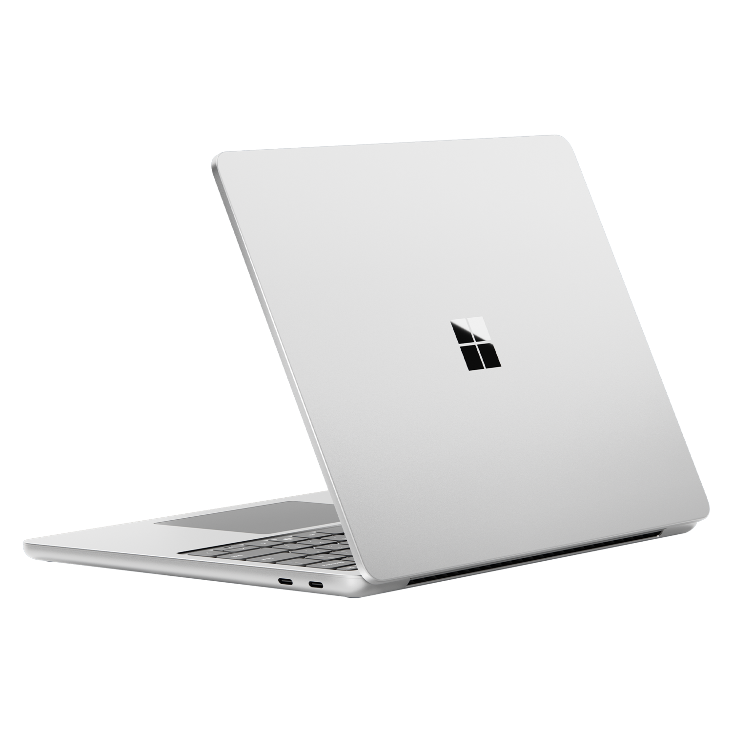 A silver laptop, slightly open, against a black background. The Microsoft logo is visible on the lid.