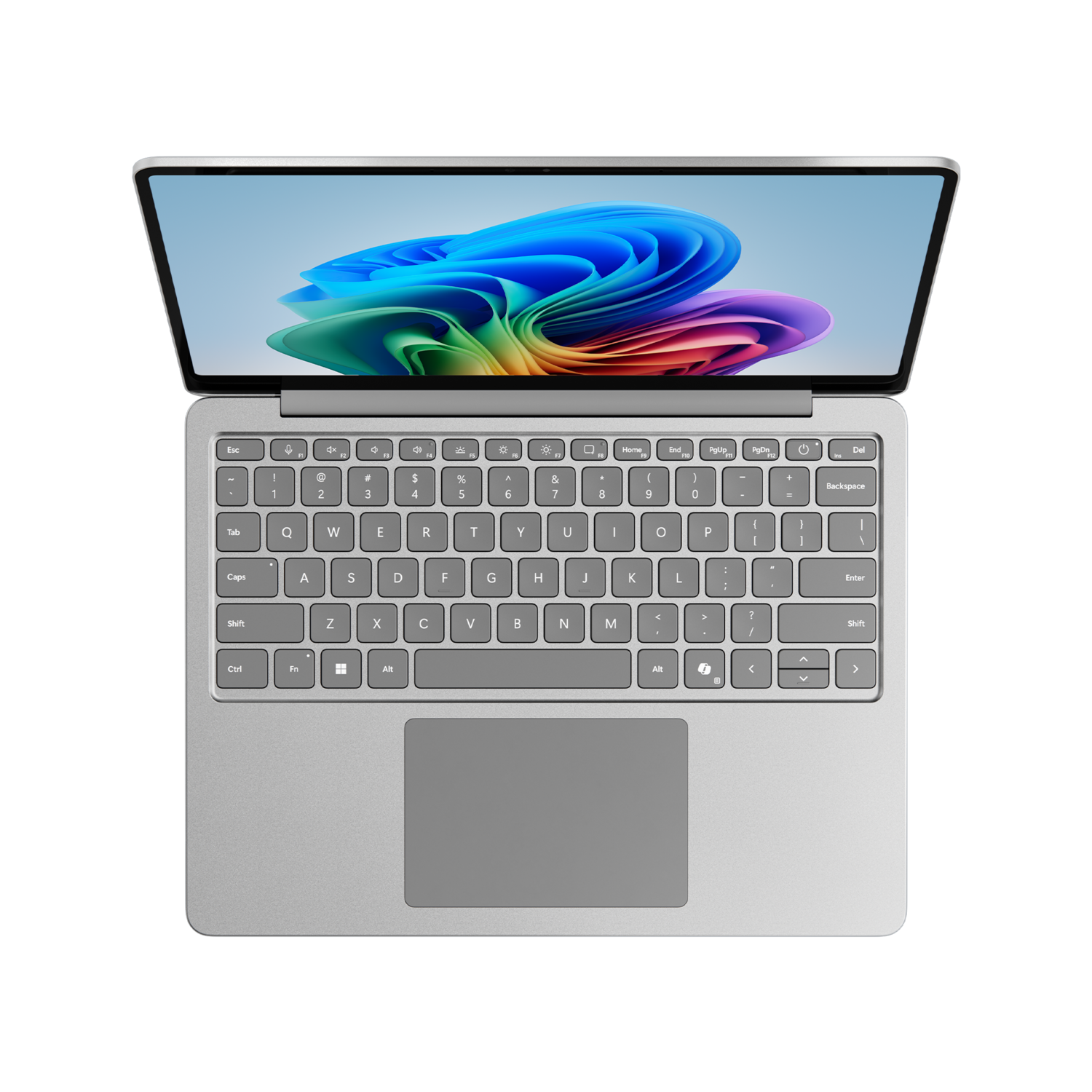 A silver laptop is open on a black surface. The screen displays a colorful abstract image. The keyboard and touchpad are visible.