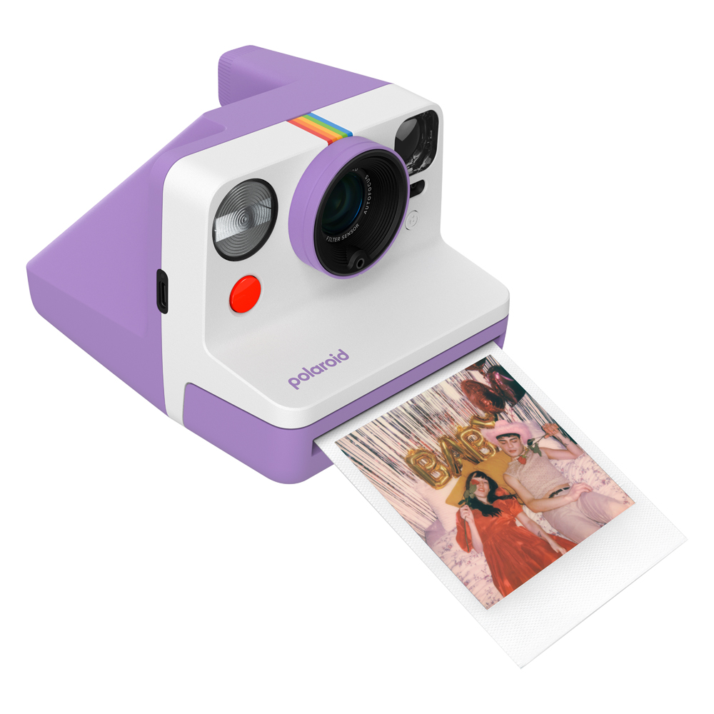 Mor Polaroid kamera, beyaz ön kısım, gökkuşağı şeridi, üzerinde insanlarla bir fotoğraf çıkarıyor, hepsi beyaz zemin üzerinde.