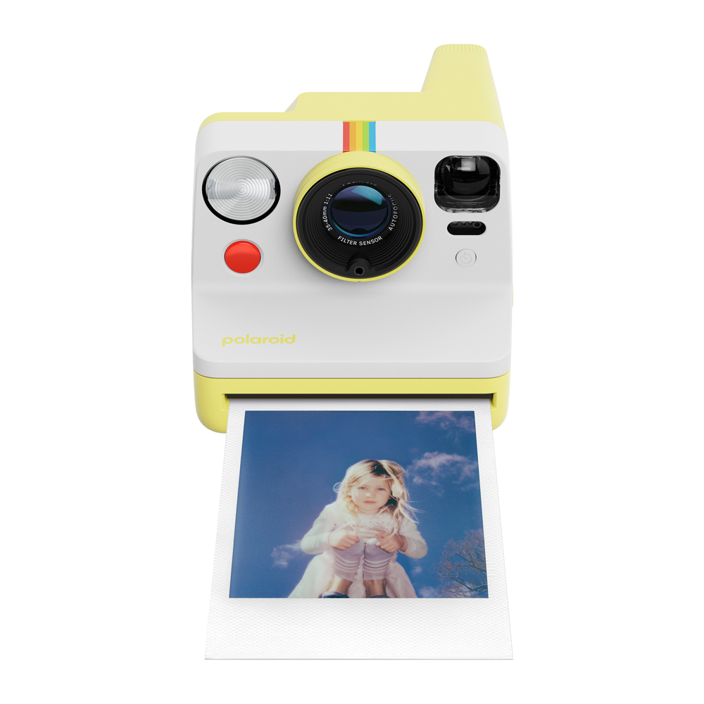 Bir kızın fotoğrafı ve mavi gökyüzü olan sarı ve beyaz Polaroid kamera hareket halinde.