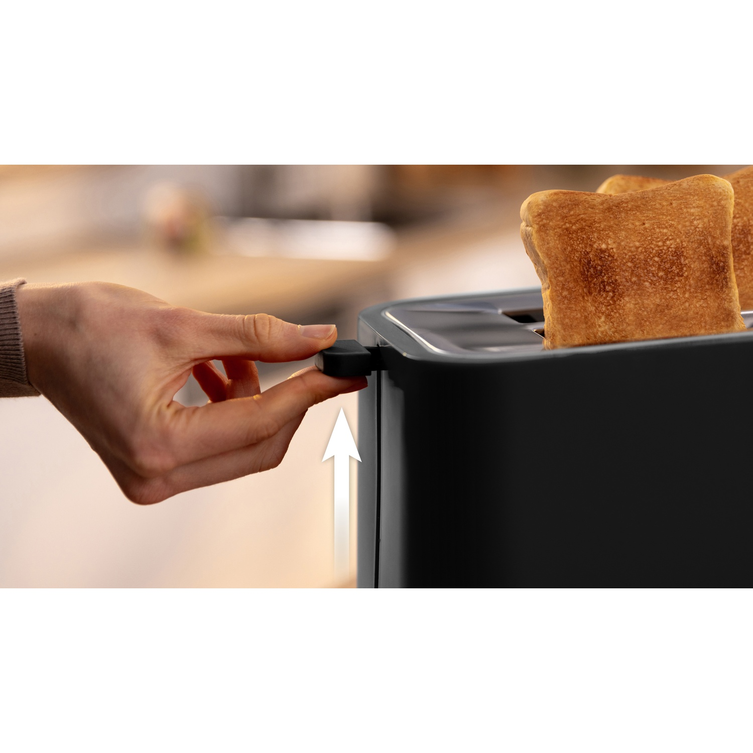 Mano che preme la leva di un tostapane nero. Due fette di pane tostato sono all'interno.