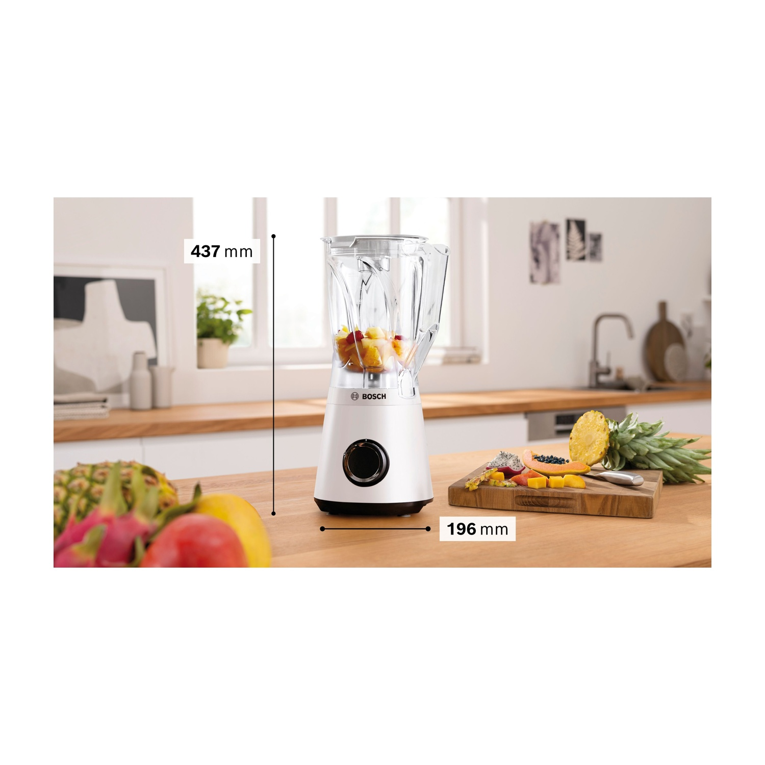 Frullatore bianco con frutta, misure: 437 mm altezza, 196 mm larghezza, e tagliere con frutta.