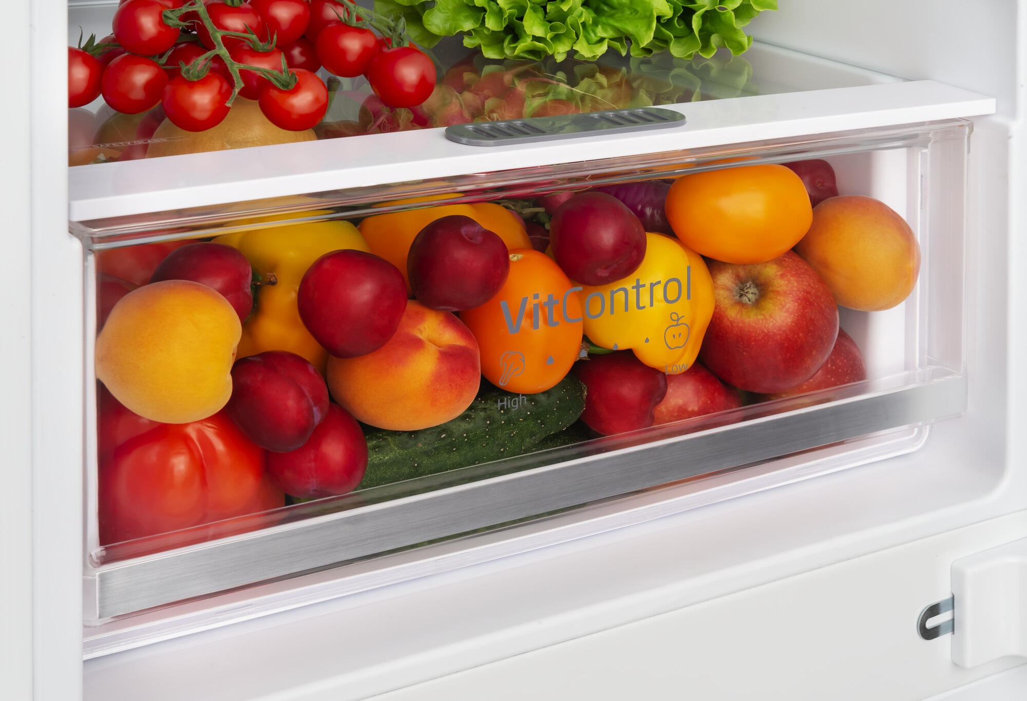 Gemüseschublade in einem Kühlschrank, gefüllt mit frischen Produkten wie Äpfeln und Pflaumen.
