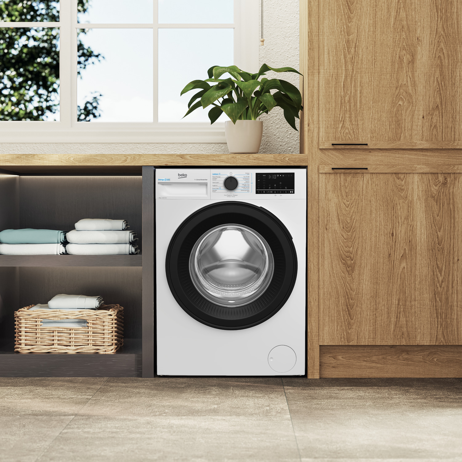 Een wasmachine staat naast een houten kast. Boven is een raam en links een plank. Een plant staat boven de wasmachine.