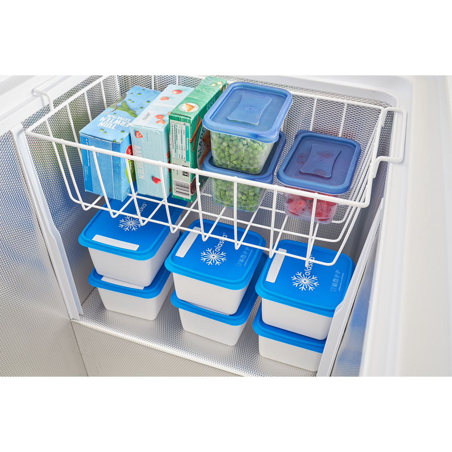 Intérieur de congélateur avec des conteneurs empilés à couvercle bleu et des boîtes d'aliments surgelés. Panier en fil de fer blanc et compartiments visibles.