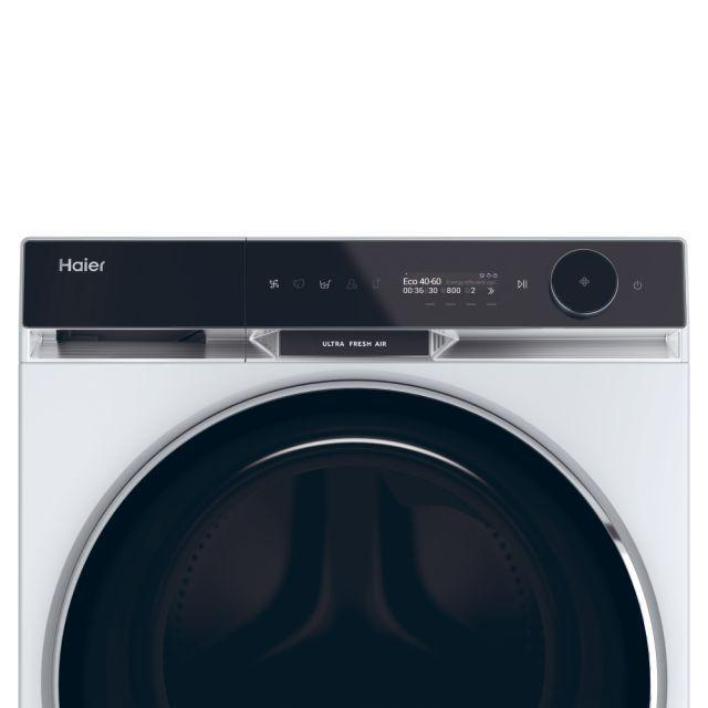 Eine weiße Waschmaschine von Haier. Die Oberseite ist schwarz mit einer Anzeige. Unten ist eine dunkle Tür.
