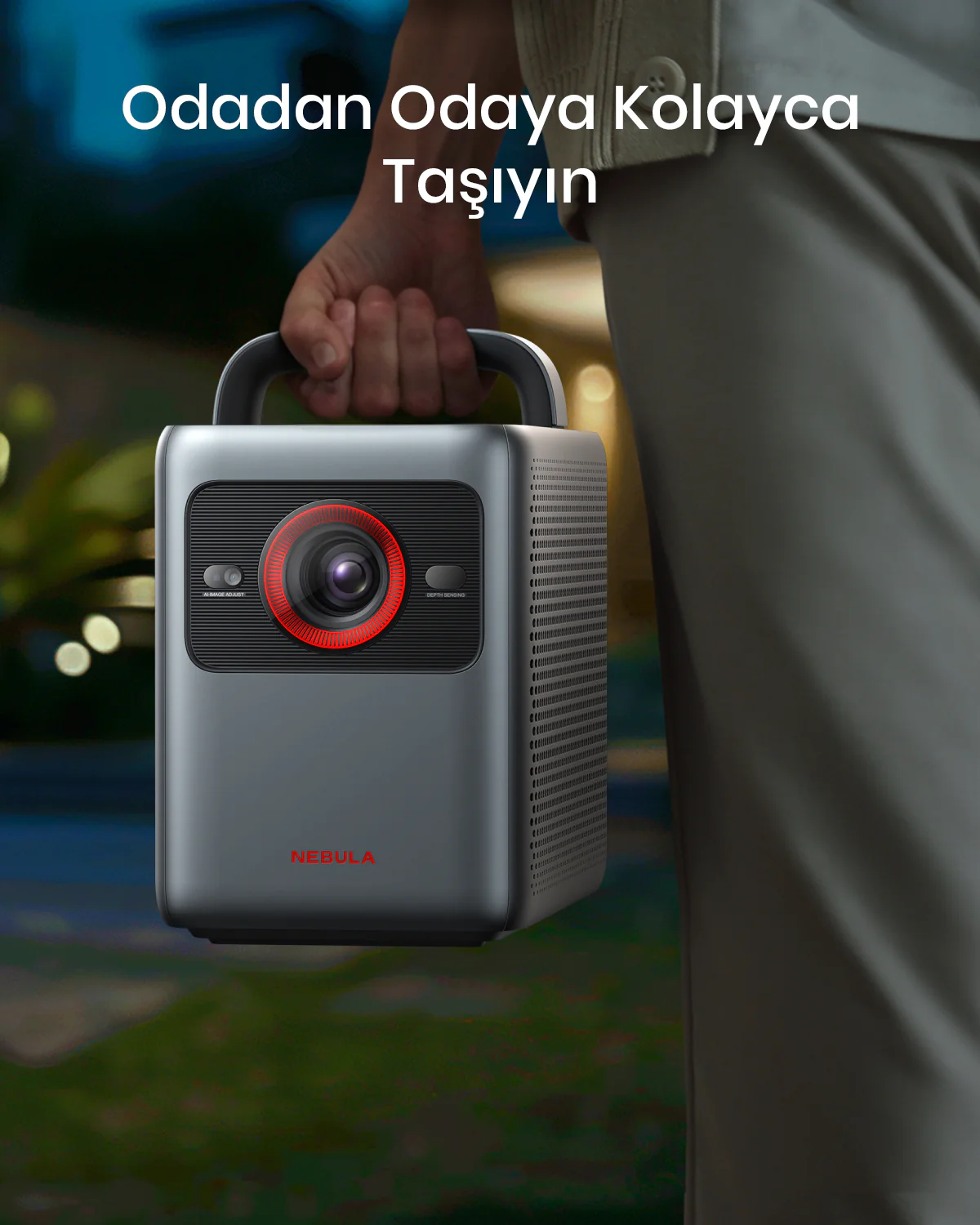 Kişi, kırmızı lensli gri Nebula projektör tutuyor. Arka plan bulanık, Türkçe metin.
