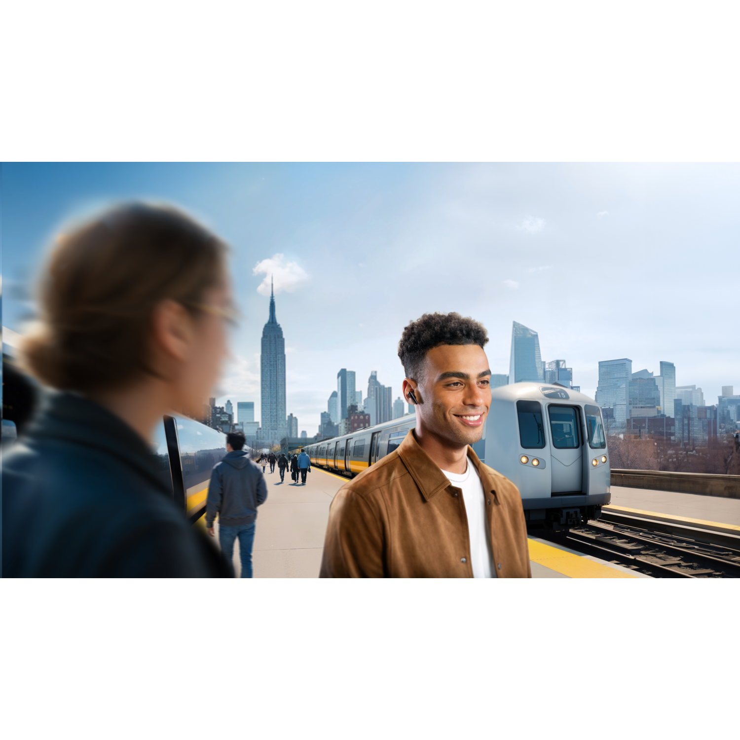 Man met oortelefoons, staand op een perron. Trein op de achtergrond. Skyline van de stad.