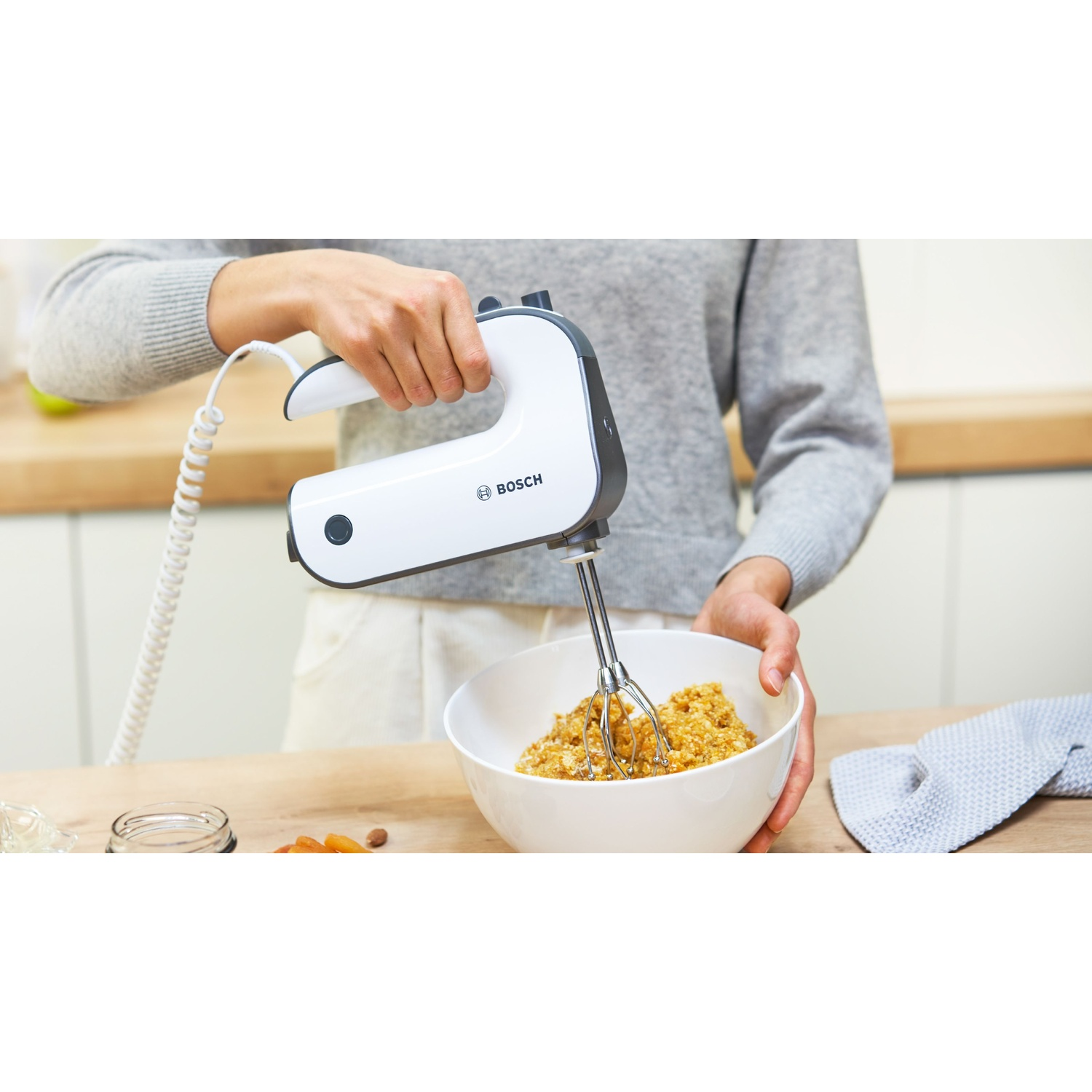 Immagini ravvicinate che evidenziano i dettagli di un frullatore a mano bianco e grigio e degli accessori.