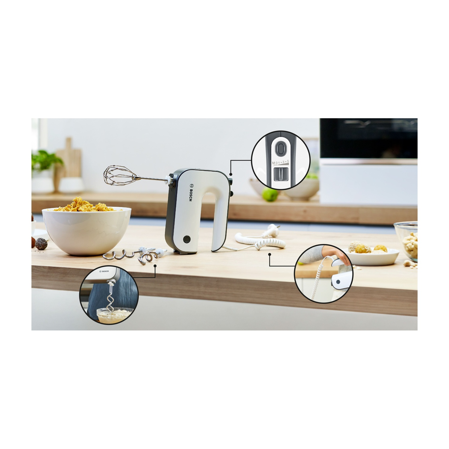 Un frullatore a mano bianco e grigio con accessori appoggiati su una superficie chiara.