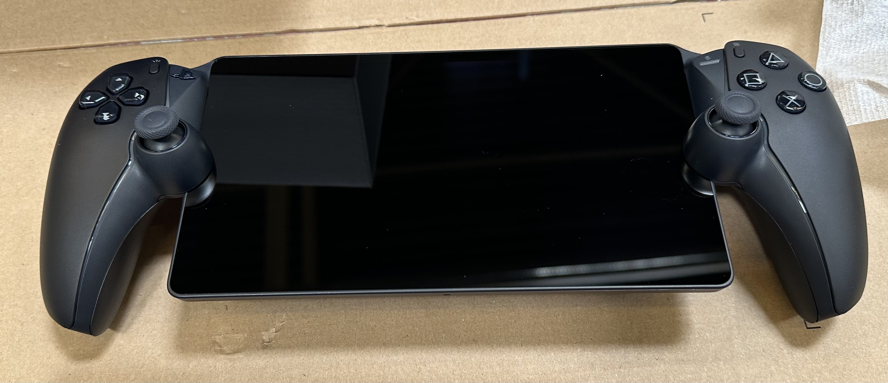 Czarny PlayStation Portal z dołączonymi kontrolerami.
