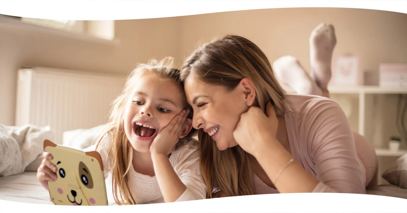 Dziewczynka i kobieta uśmiechają się, patrząc na tablet.