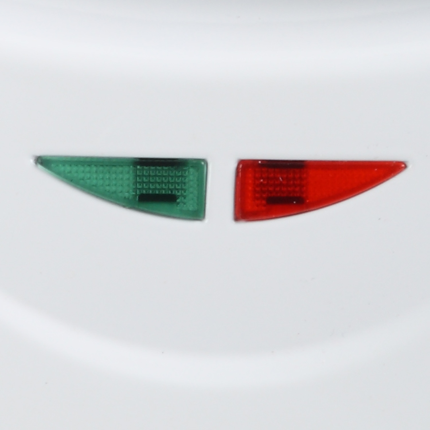 Primo piano di un elettrodomestico bianco con spie verdi e rosse, angolate, che mostrano la loro forma.