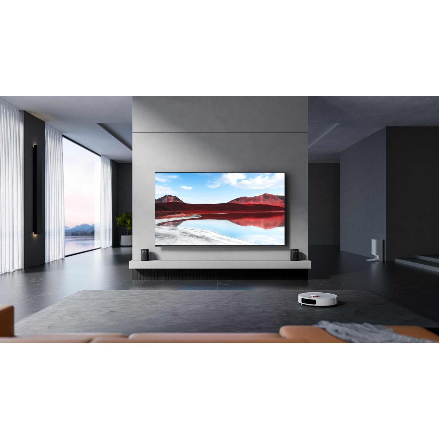 Soggiorno moderno con TV che mostra un paesaggio. Un robot aspirapolvere pulisce il pavimento. Grandi finestre.