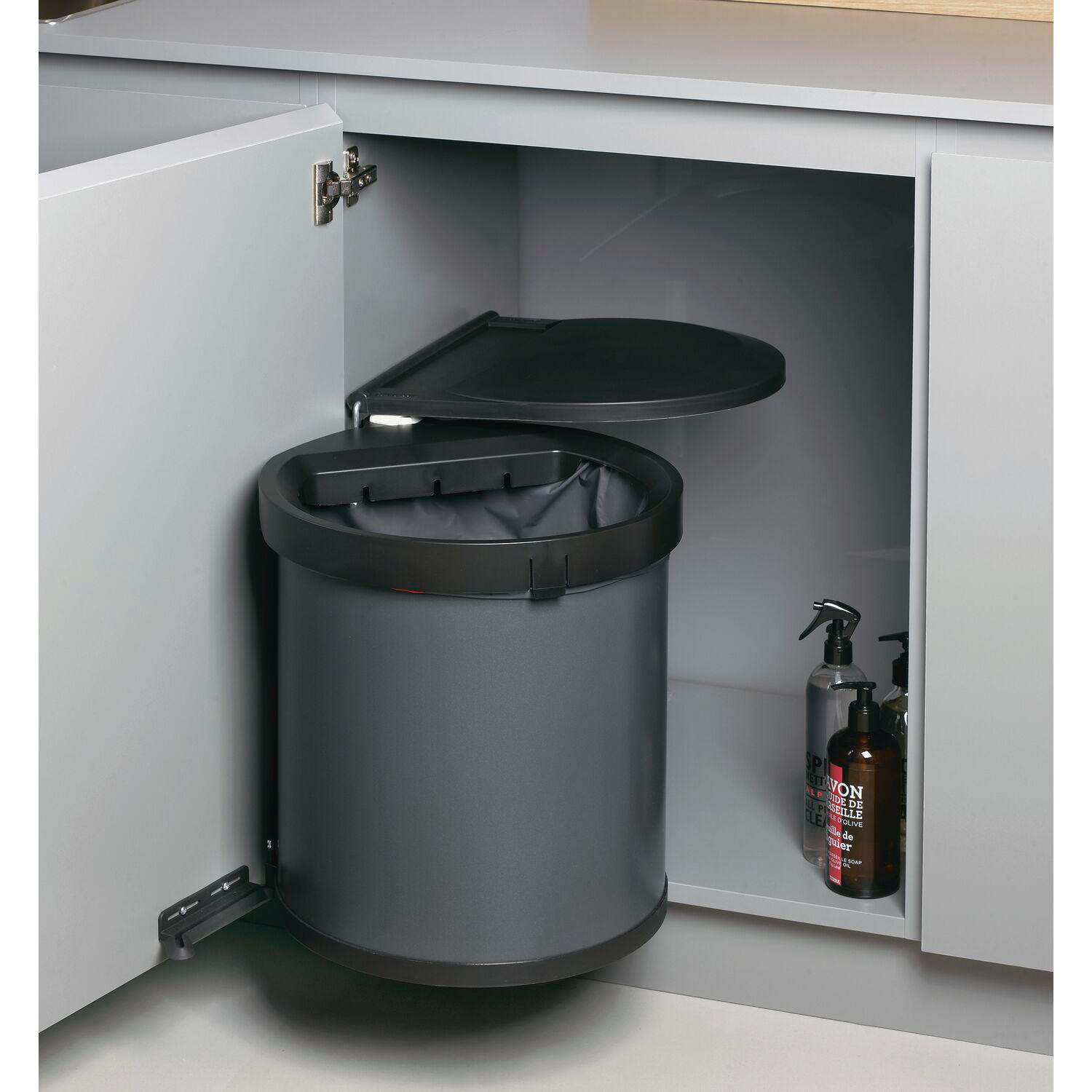 Ein Mülleimer in einem Küchenschrank mit Reinigungsmitteln.
