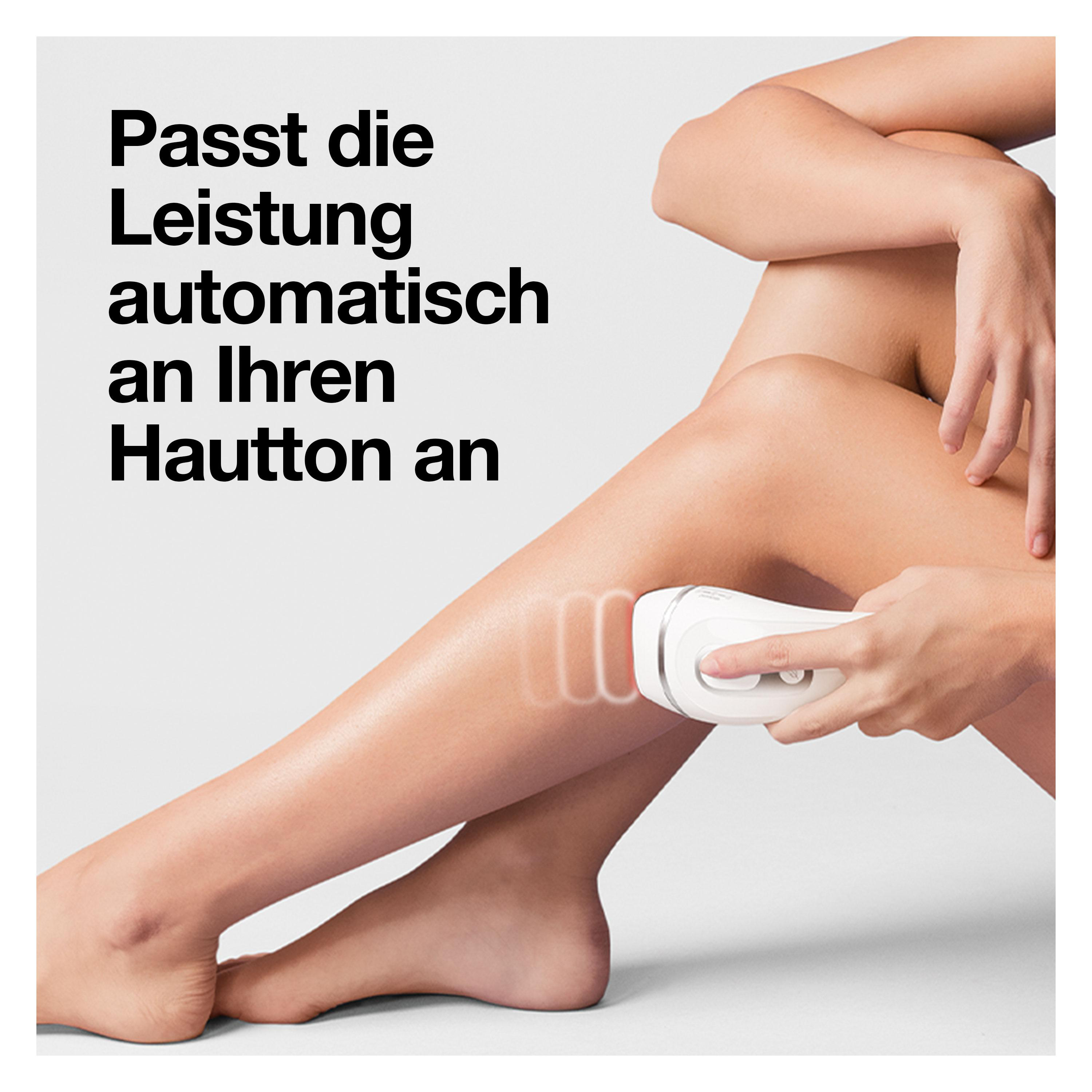 Eine Frau benutzt ein weißes Haarentfernungsgerät an ihrem Oberschenkel.