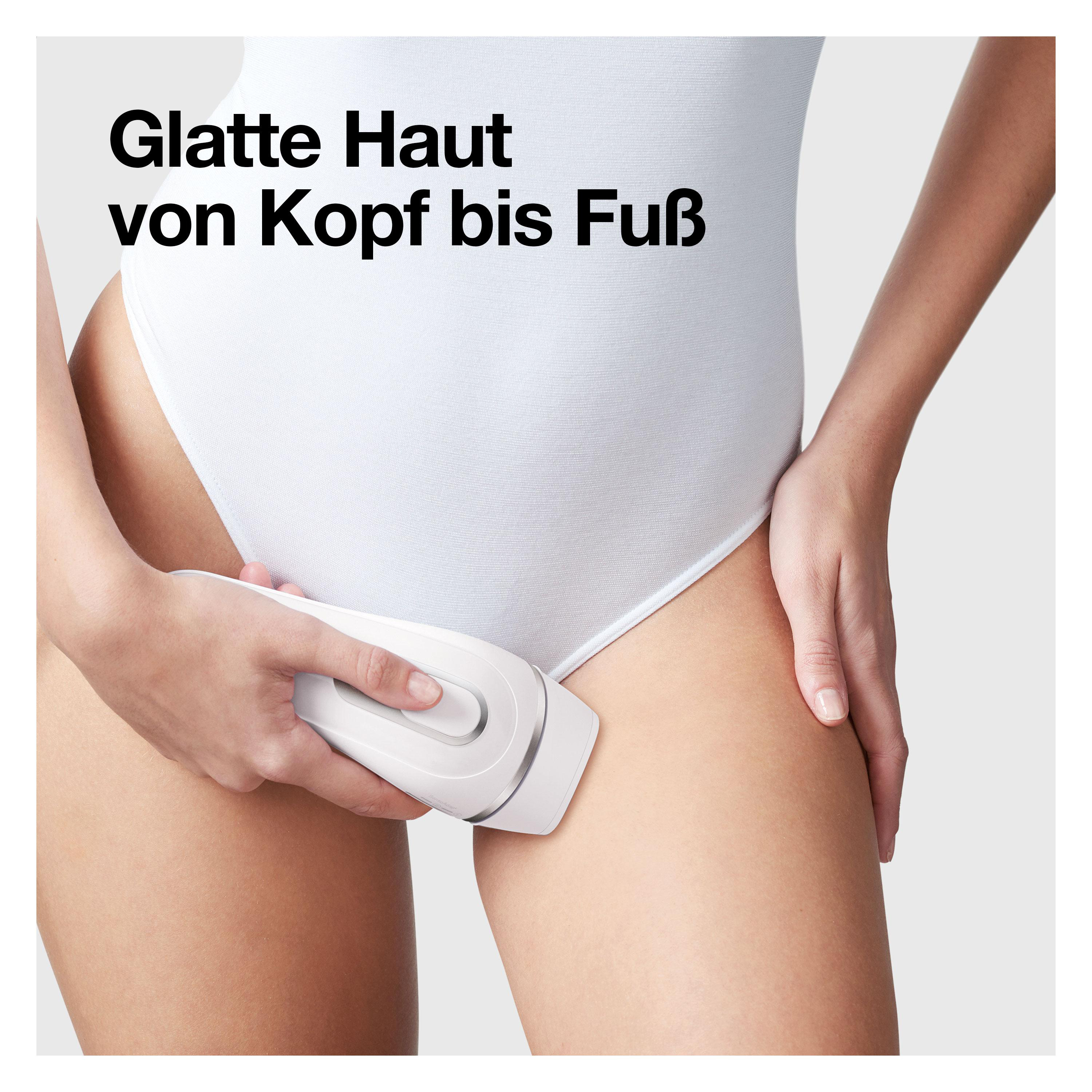 Eine Frau benutzt ein weißes Haarentfernungsgerät an ihrem Oberschenkel.